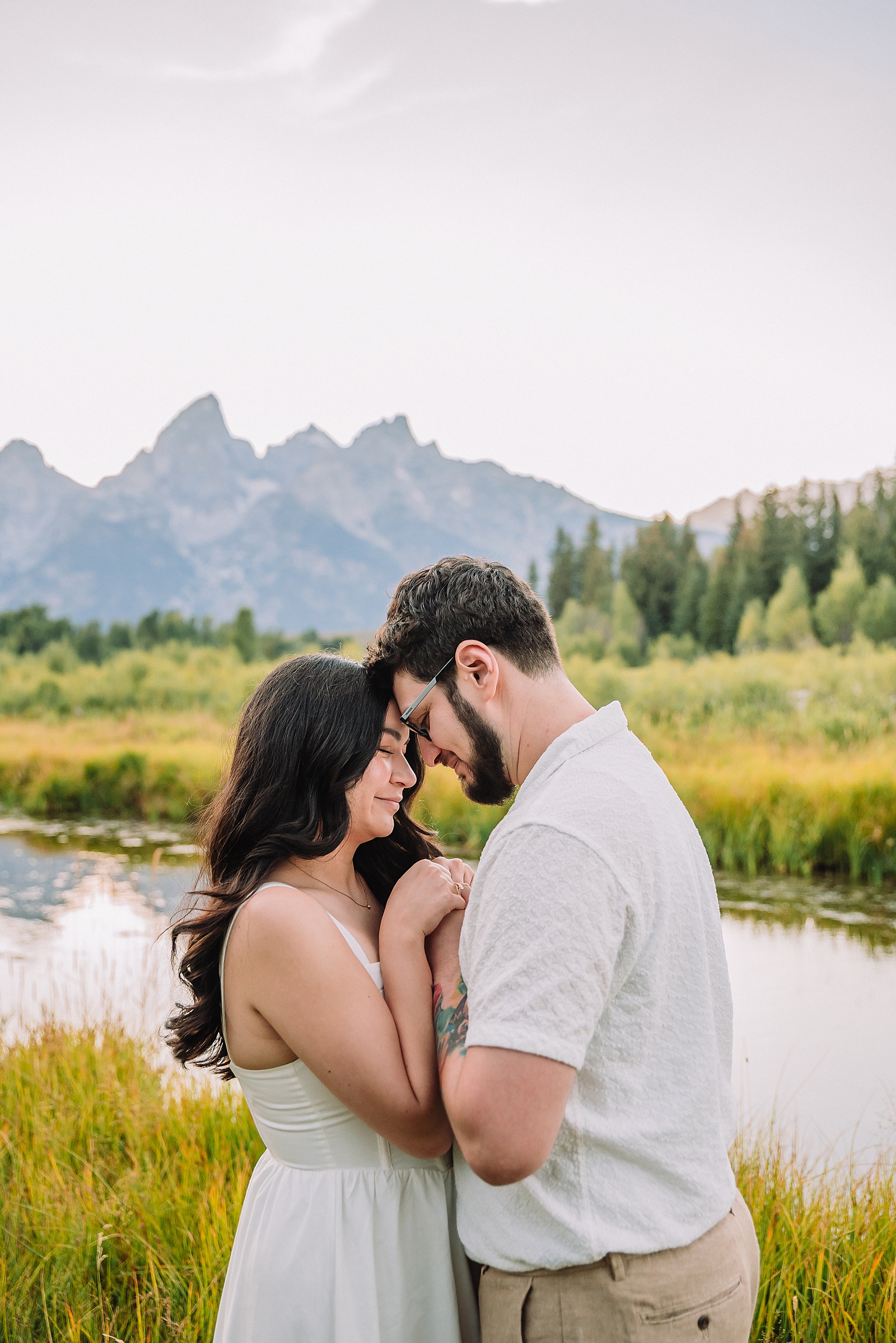 Schwabacher Landing engagement photos Grand Teton National Park white corset dress mountain engagement session Wyoming sunset engagement photos Teton mountain range backdrop couple wearing white outfits Grand Teton engagement shoot Jackson Hole Engagement Photographer