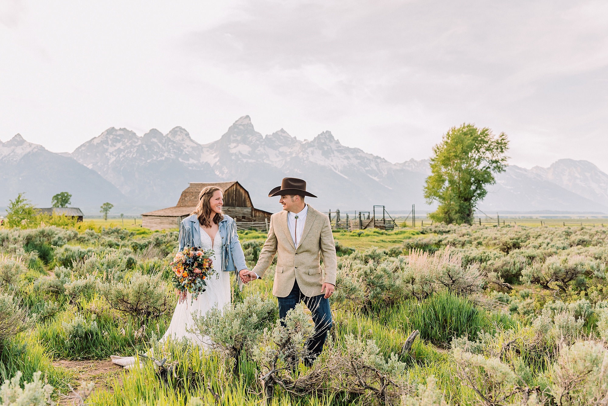 Jackson Hole Wyoming wedding photography Jackson Hole wedding photography Mormon Row portraits Bride fringed jean jacket Western wedding style