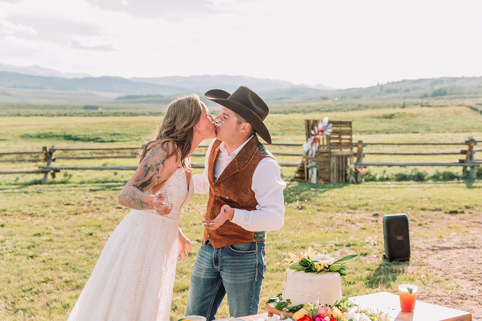 Rustic Wyoming outdoor wedding reception dance floor Faith-based knot tying wedding ceremony Wyoming Candid hilarious cake cutting wedding photos Two-day Wyoming wedding ceremony and reception photography destination Wyoming wedding photography
