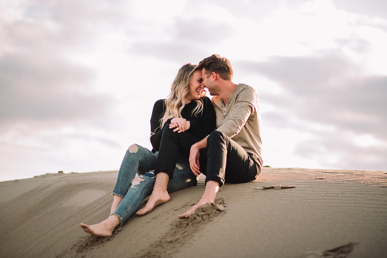 couple sitting together on the sand dunes, desert, beach