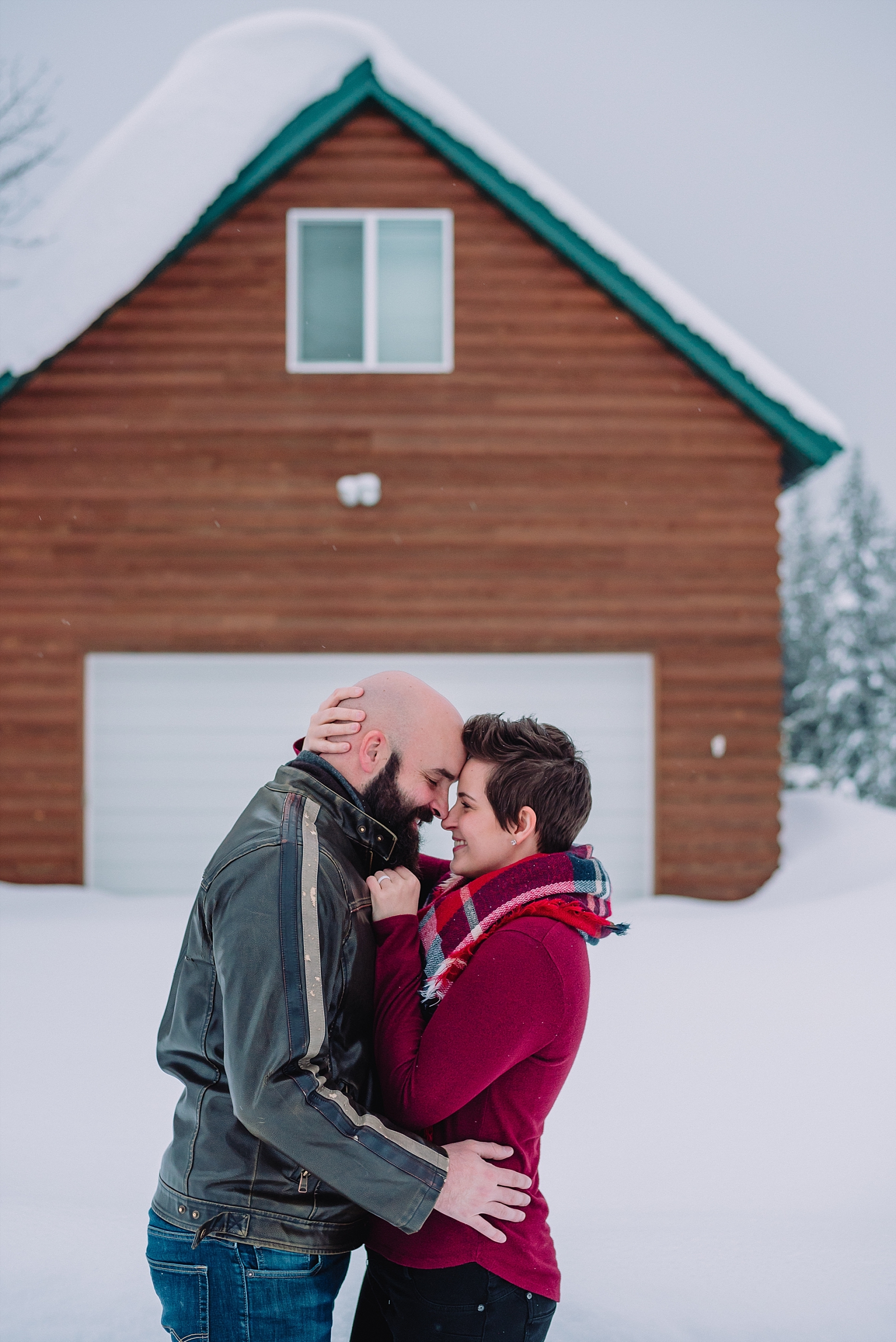 couple in front of cabin winter