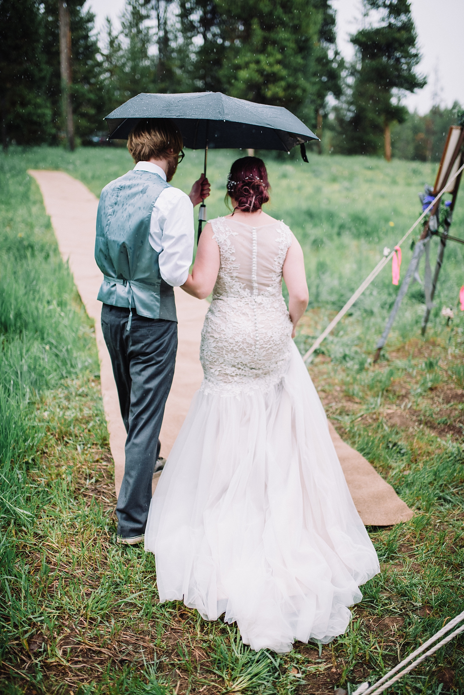 bride and groom walking umbrella rain idaho