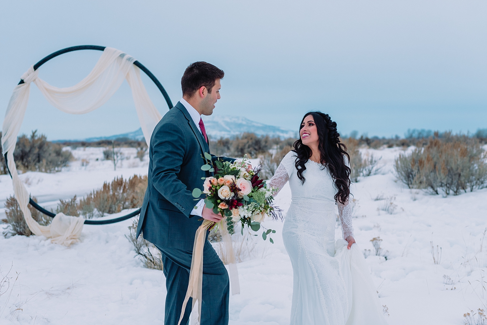 bride and groom walking through snow winter wedding