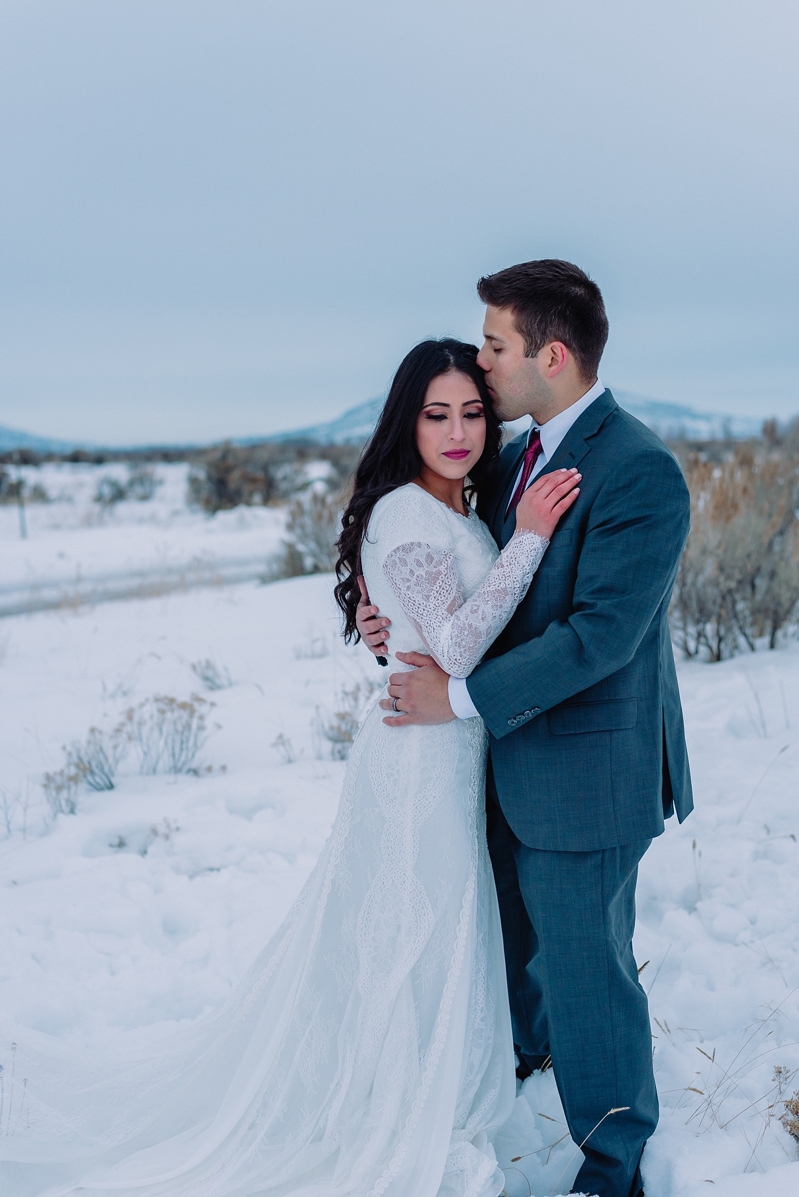bride and groom traditional pose winter wedding kissing