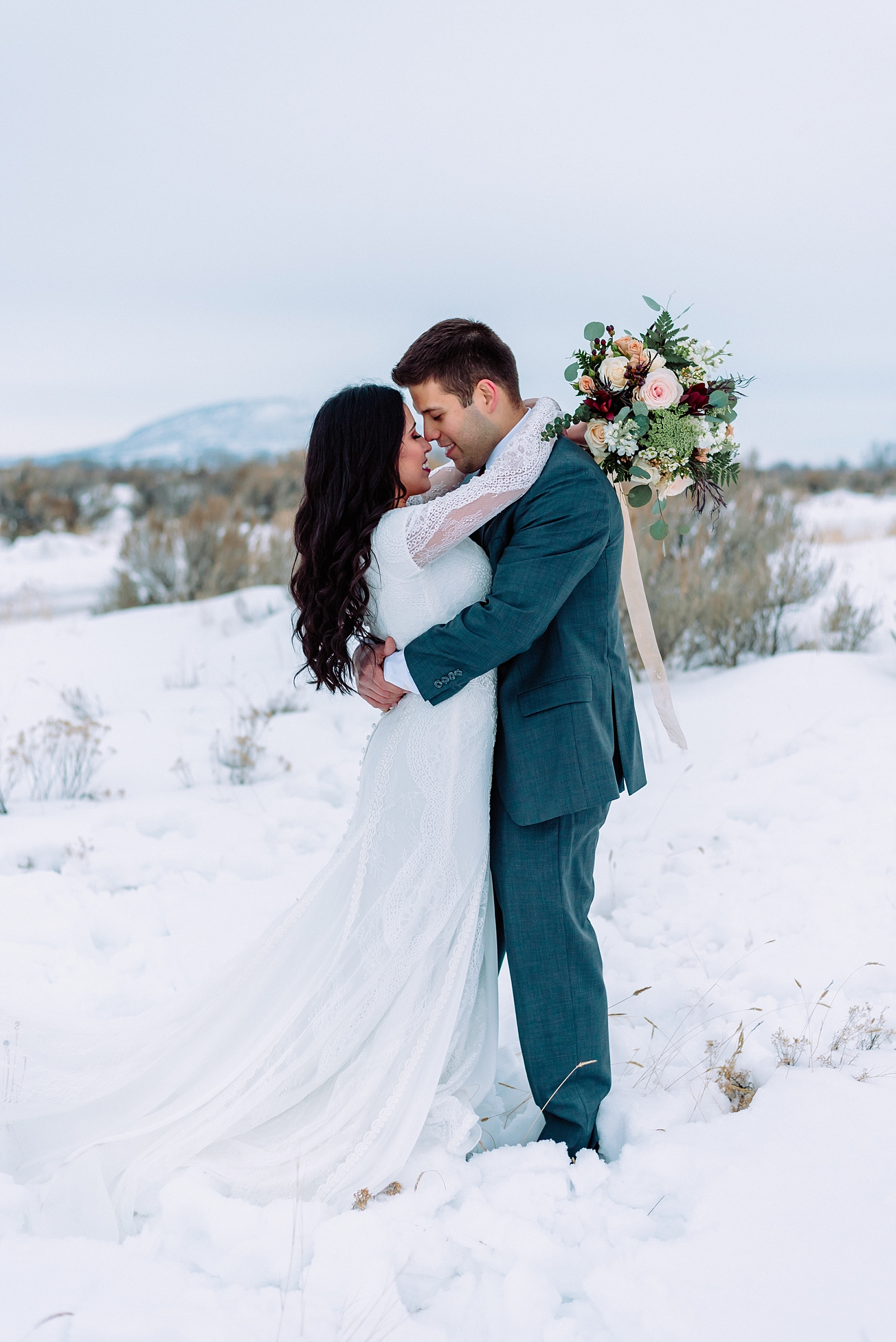 bride with arms looped over groom neck winter wedding