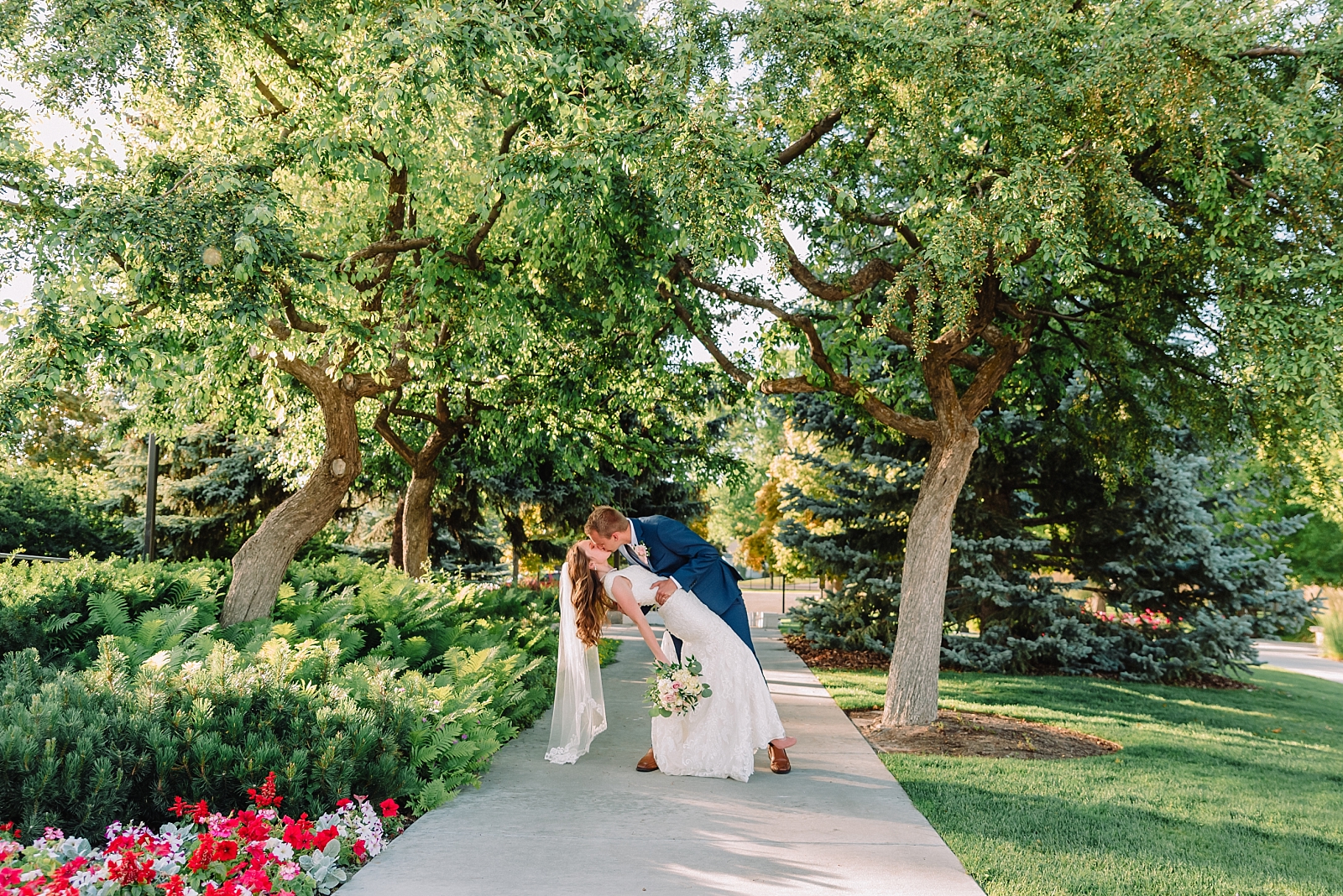 bride and groom kissing on path