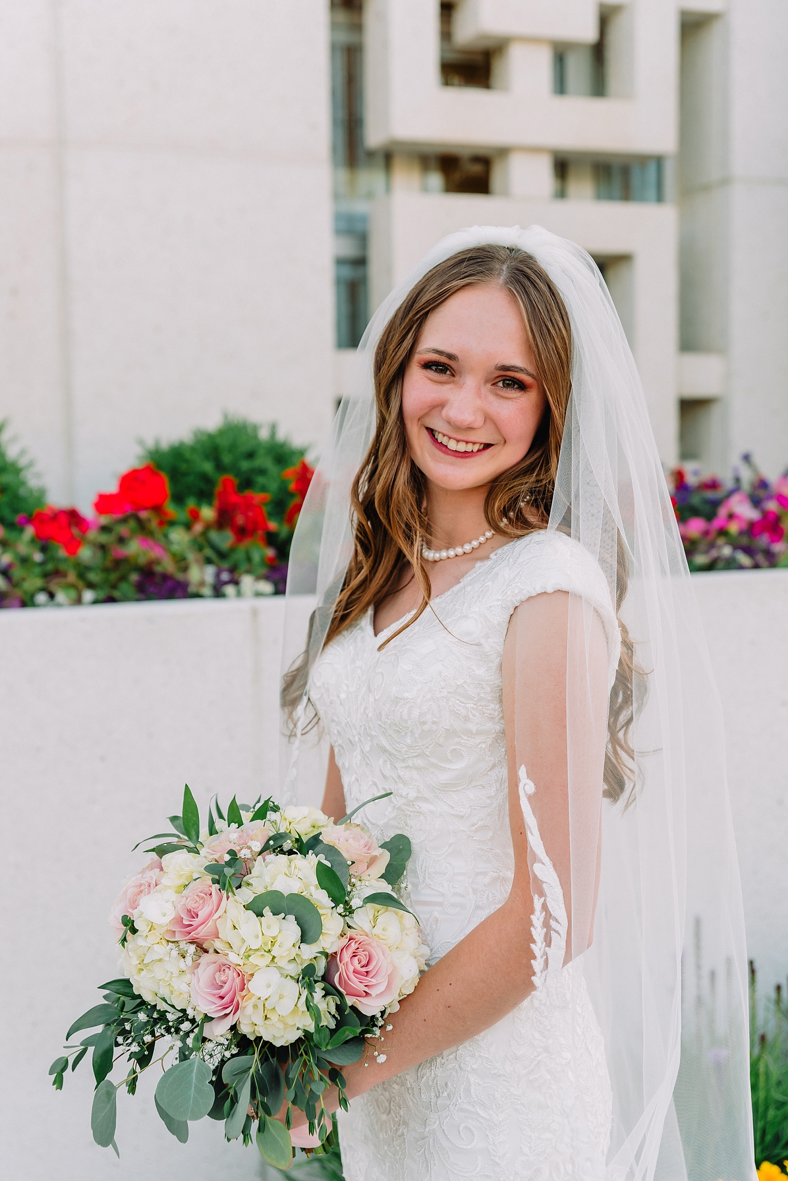 bride holding wedding bouquet in front of LDS temple