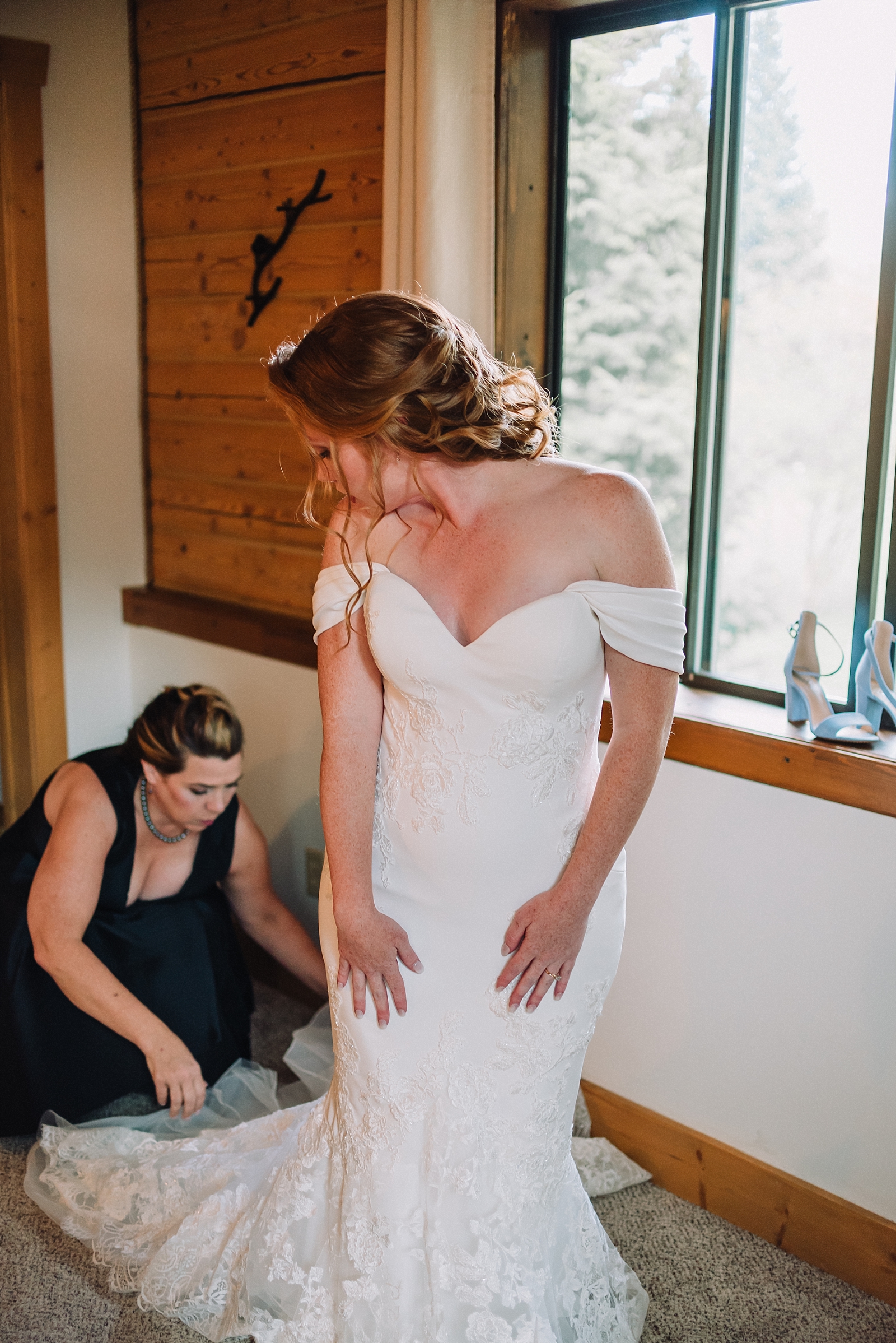 mother helping bride get ready for wedding