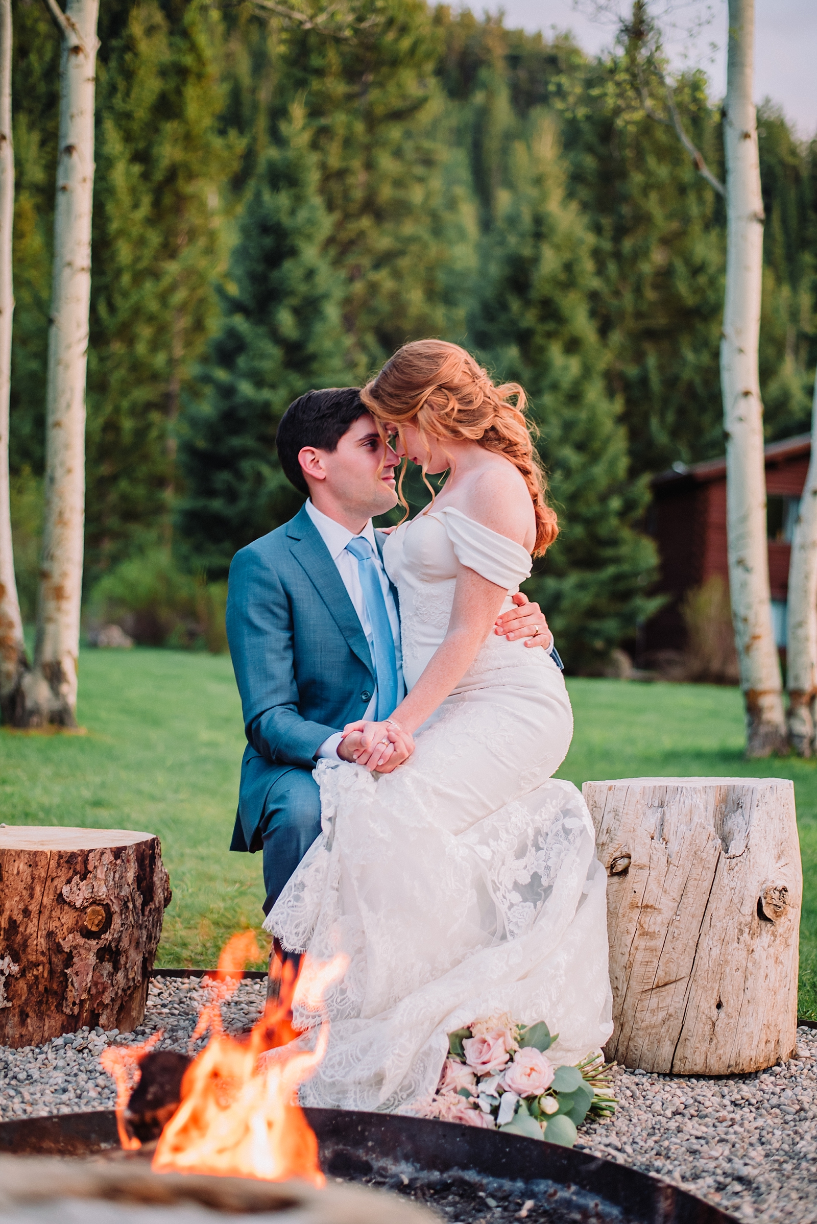 bride and groom in front of campfire