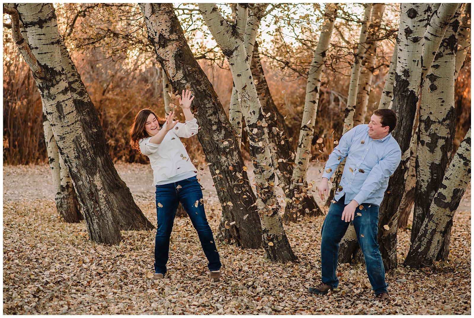 engaged couple throwing leaves at each other