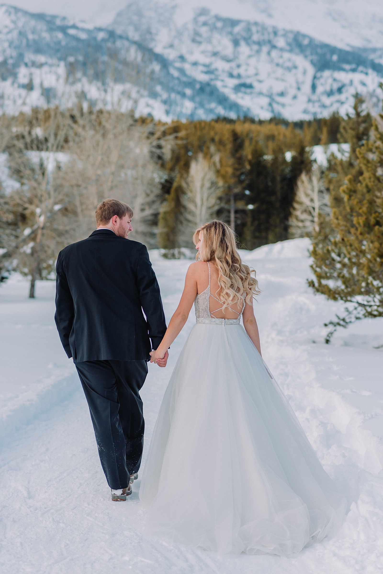 bride-and-groom-walking-hand-in-hand-jackson-hole-elopement-wedding-photographer-winter-in-the-mountains