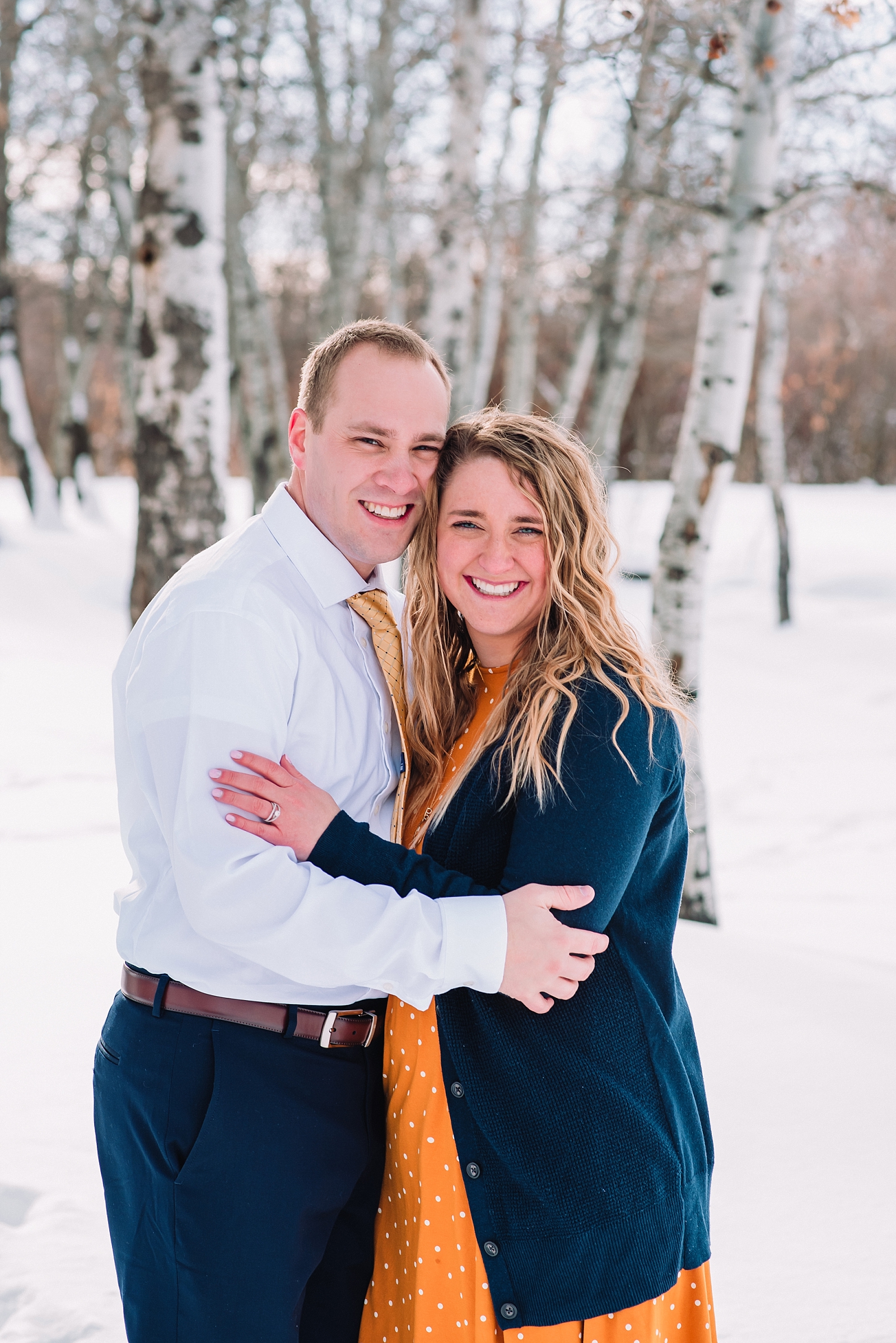 engaged couple standing in front of aspen trees fun romantic traditional wedding photography