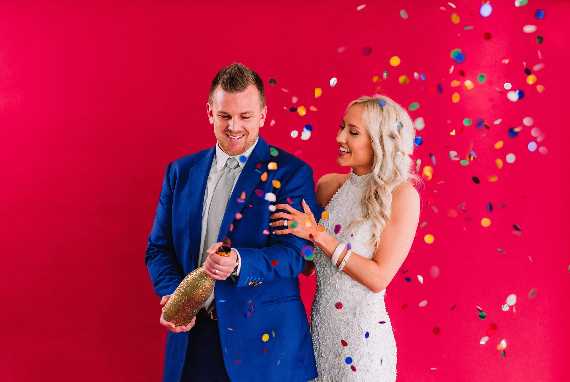 wedding-couple-champagne-bottle-confetti-popper-colorful-studio-backdrop