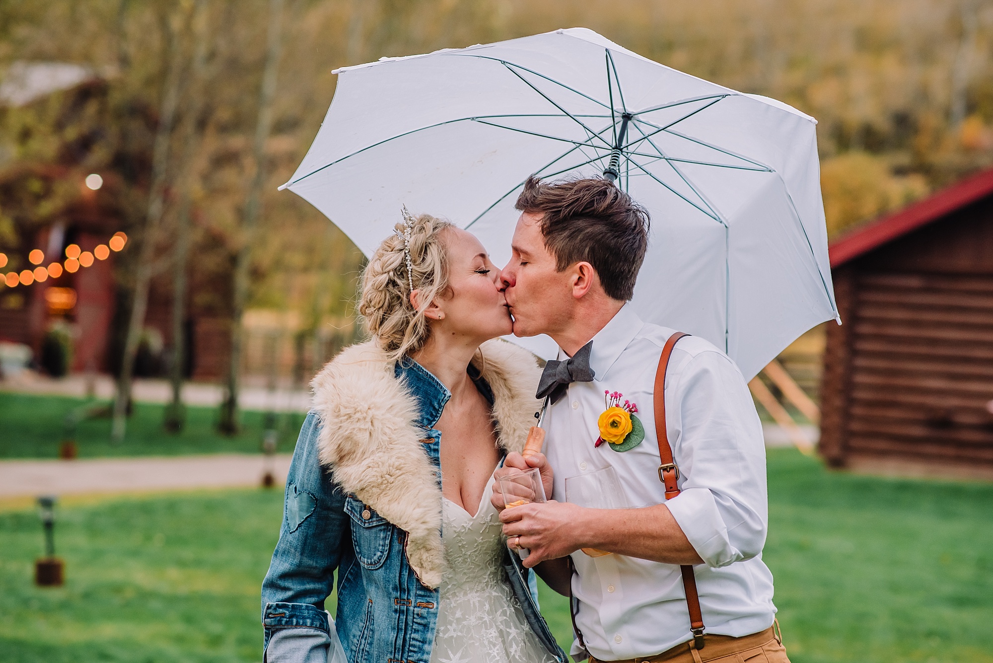 bride-and-groom-kissing-under-umbrella