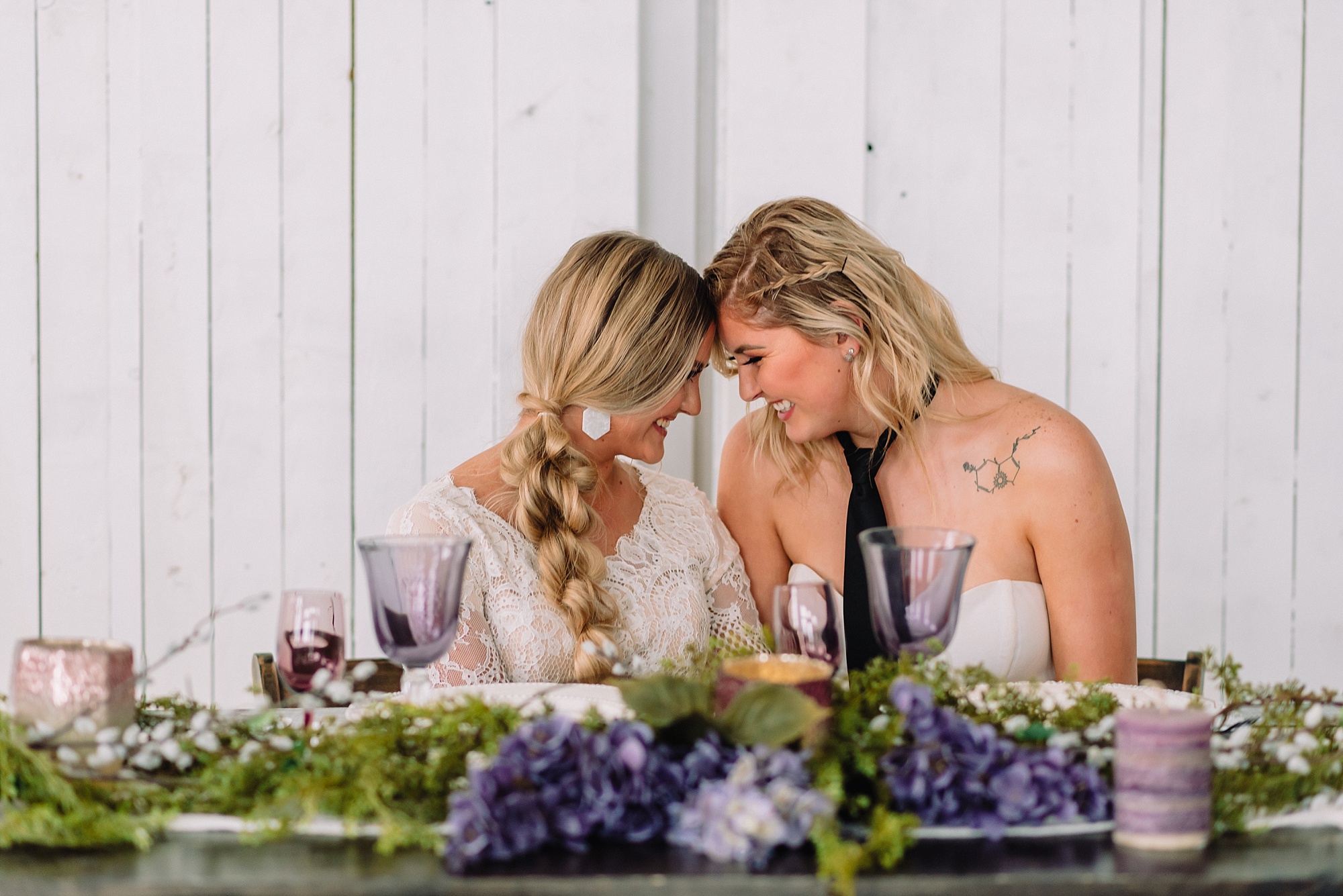 brides with foreheads together at reception dinner