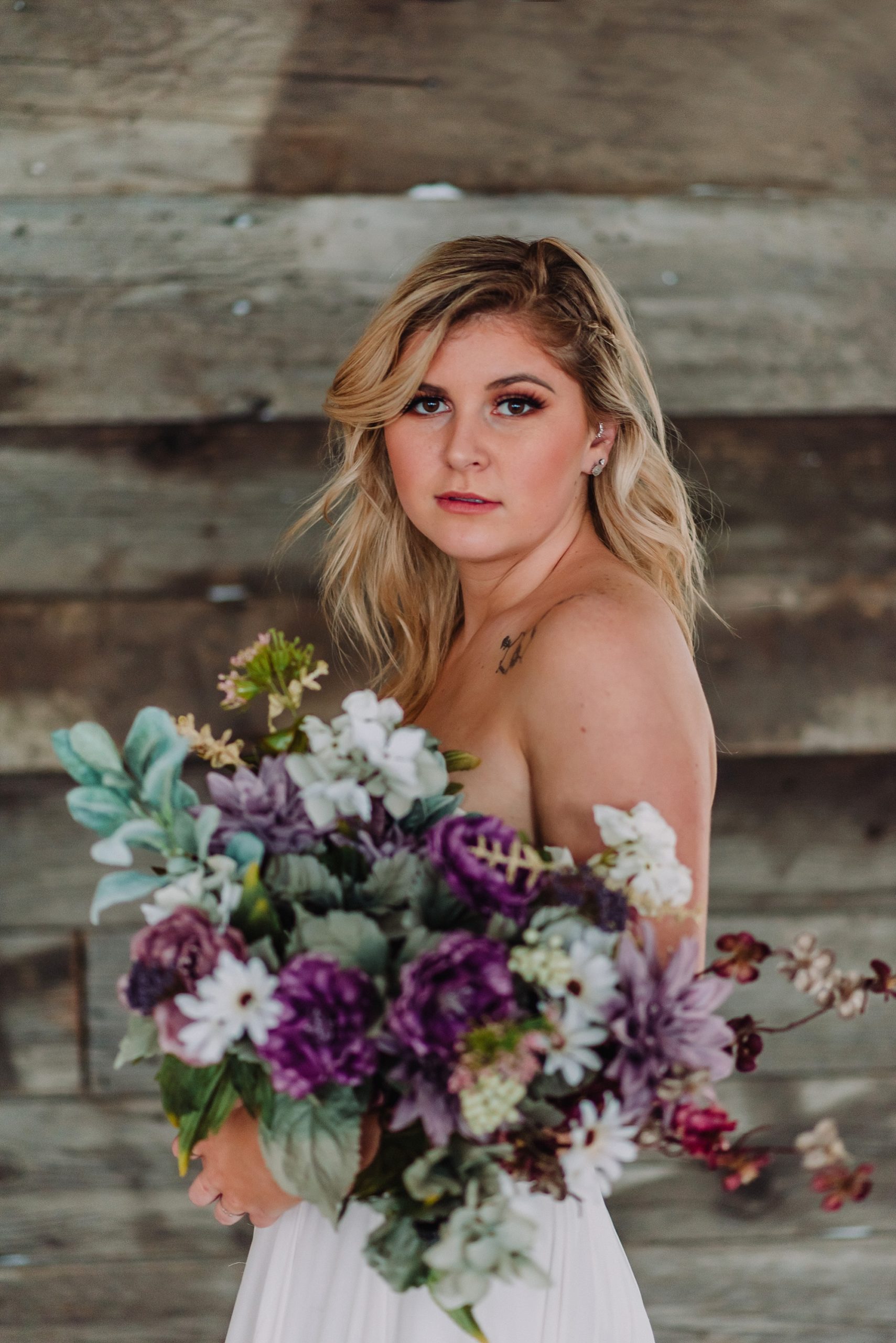 bride with wedding bouquet and flowers lesbian wedding flower inspiration purple and sage