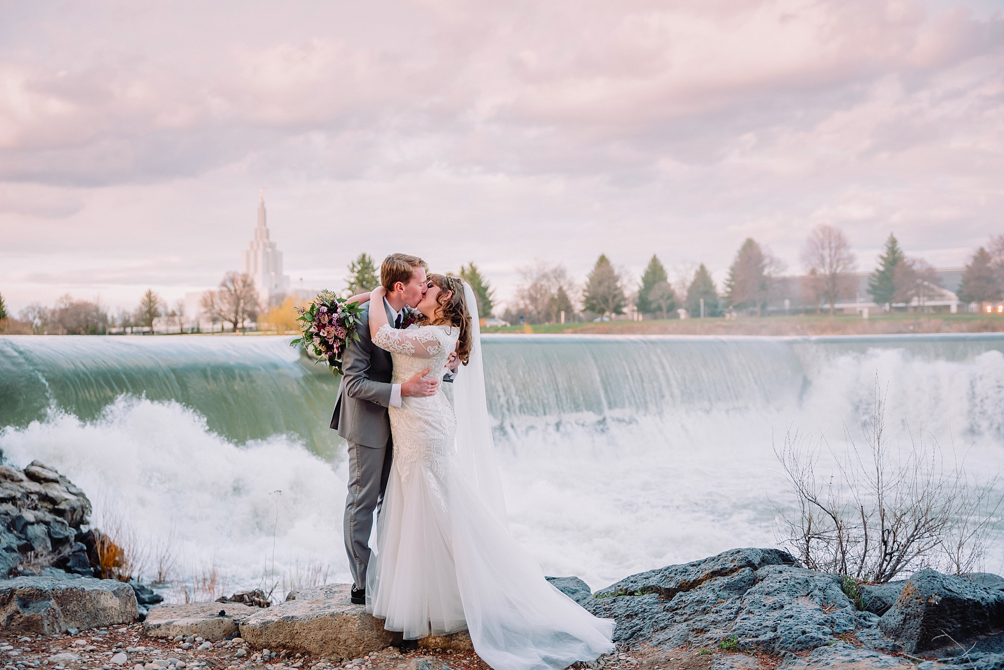 bride-and-groom-kissing-at-the-waterfall-at-the-idaho-falls-greenbelt