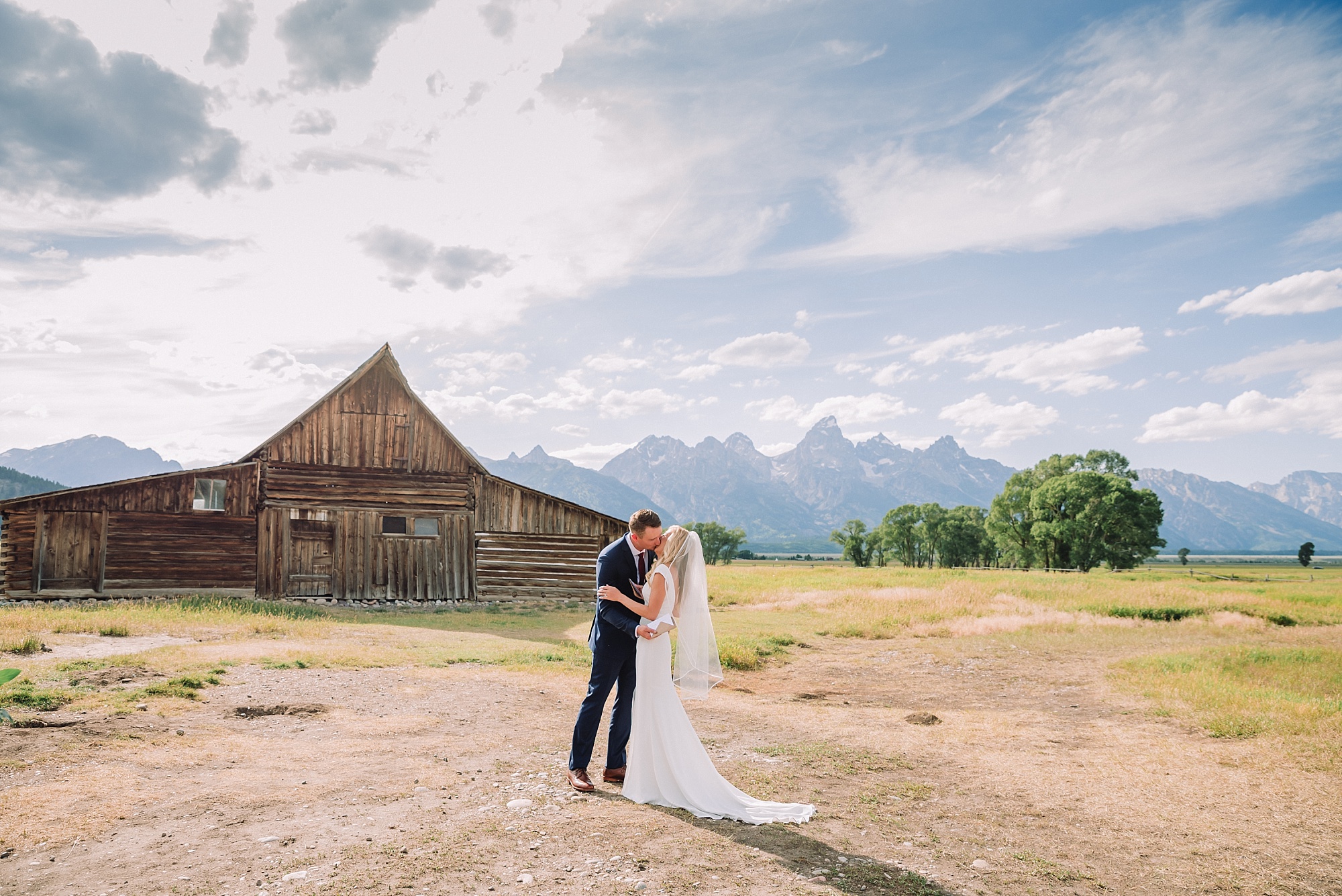 bride and groom kissing at mormon row in Grand Teton National Park