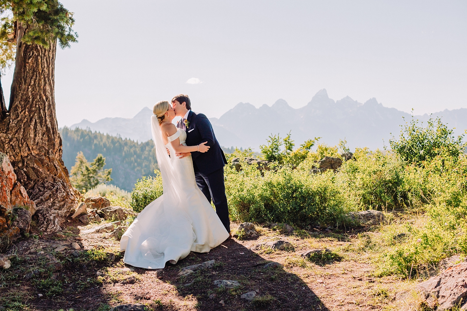 bride and groom kiss in teton mountains
