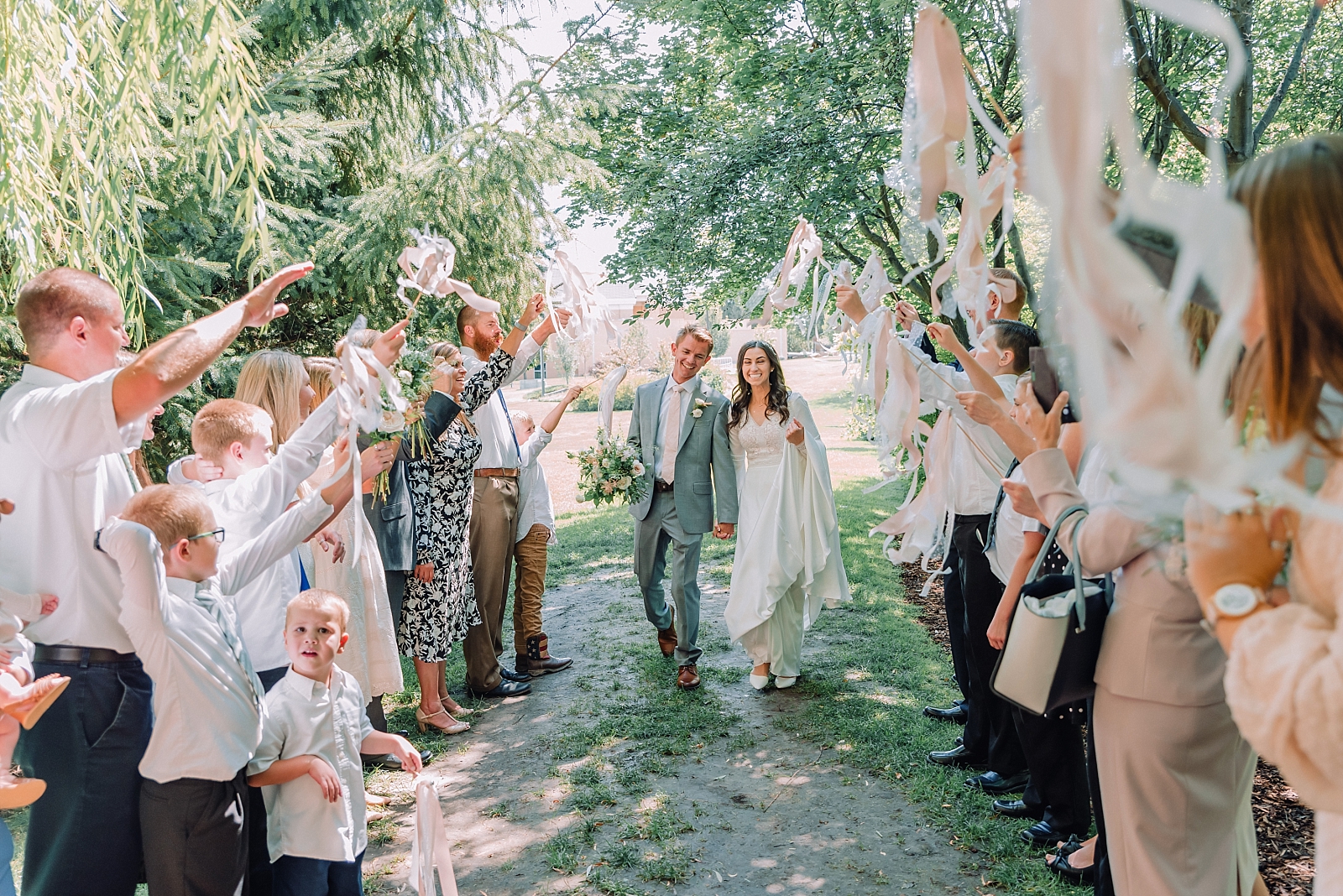 bride and groom leaving their reception with family and friends throwing petals on them