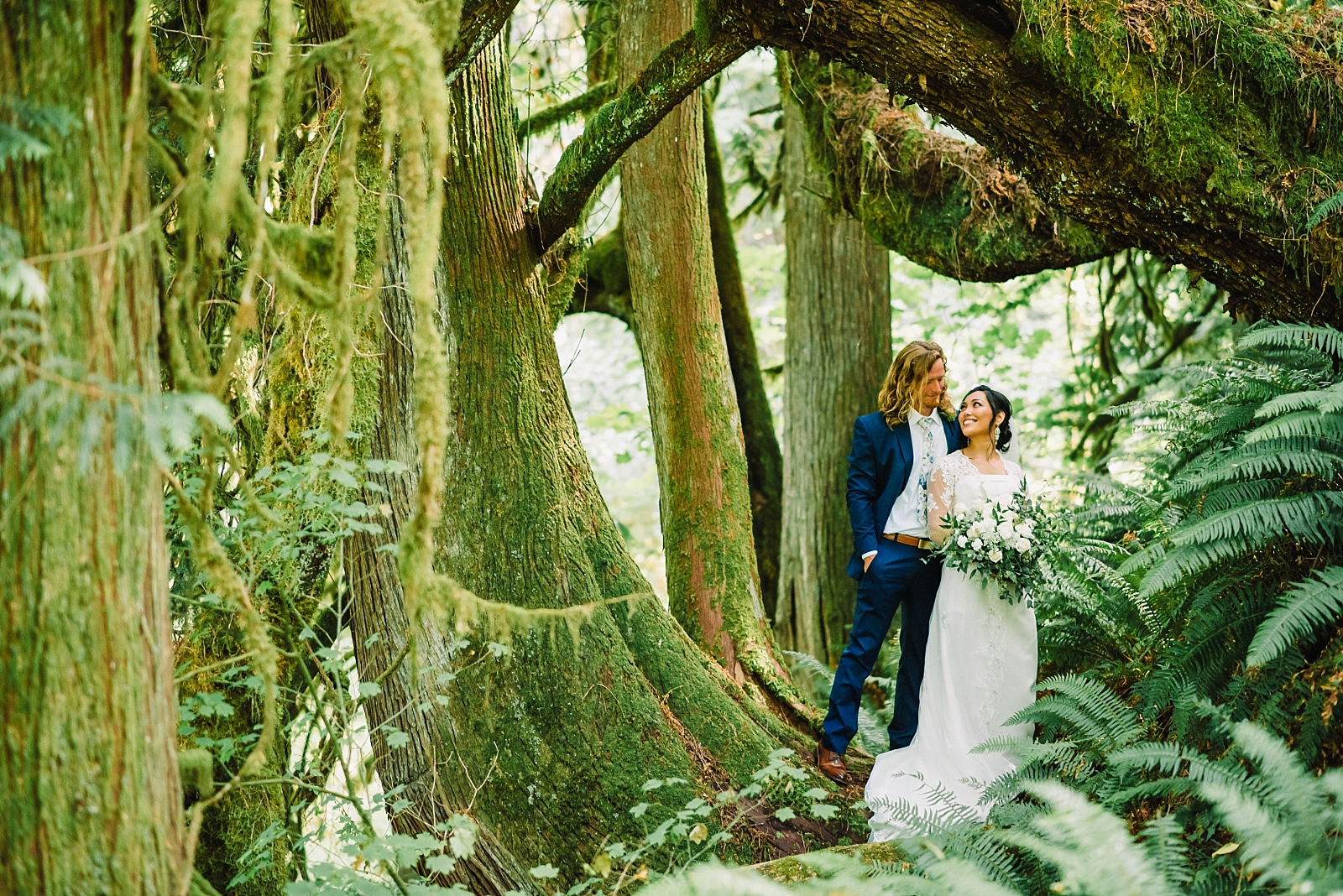 bride and groom under curvy tree