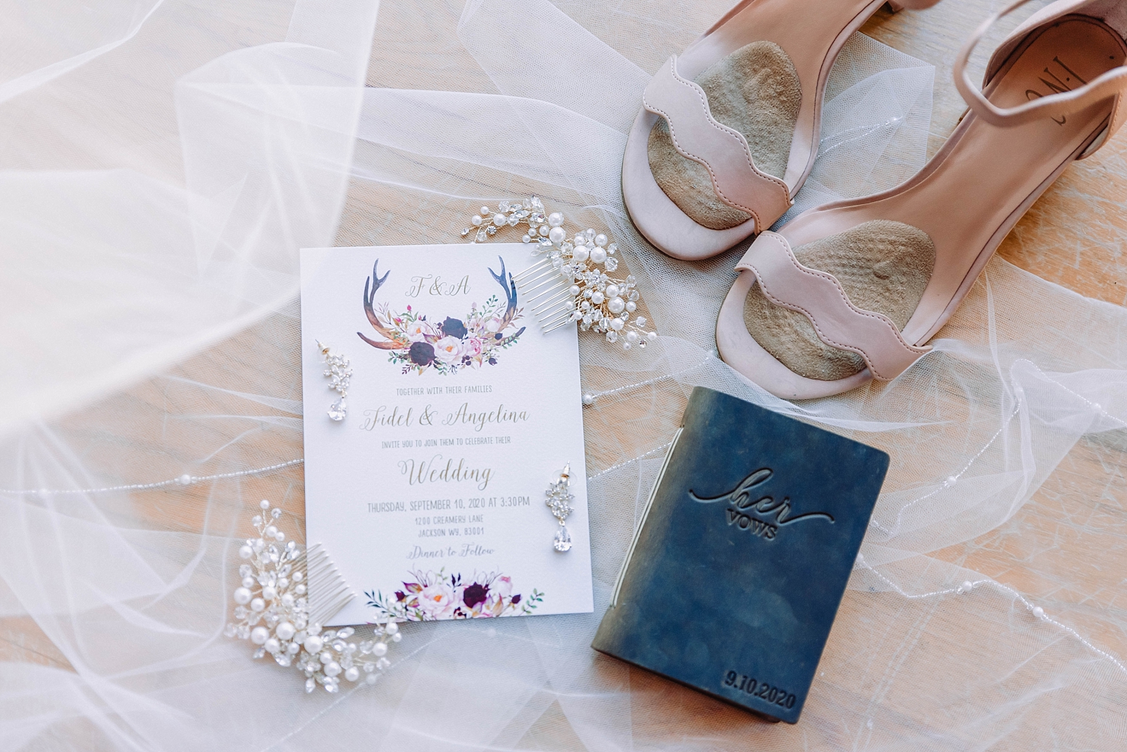 bridal details with wedding invitation on lace veil with blush bridal shoes