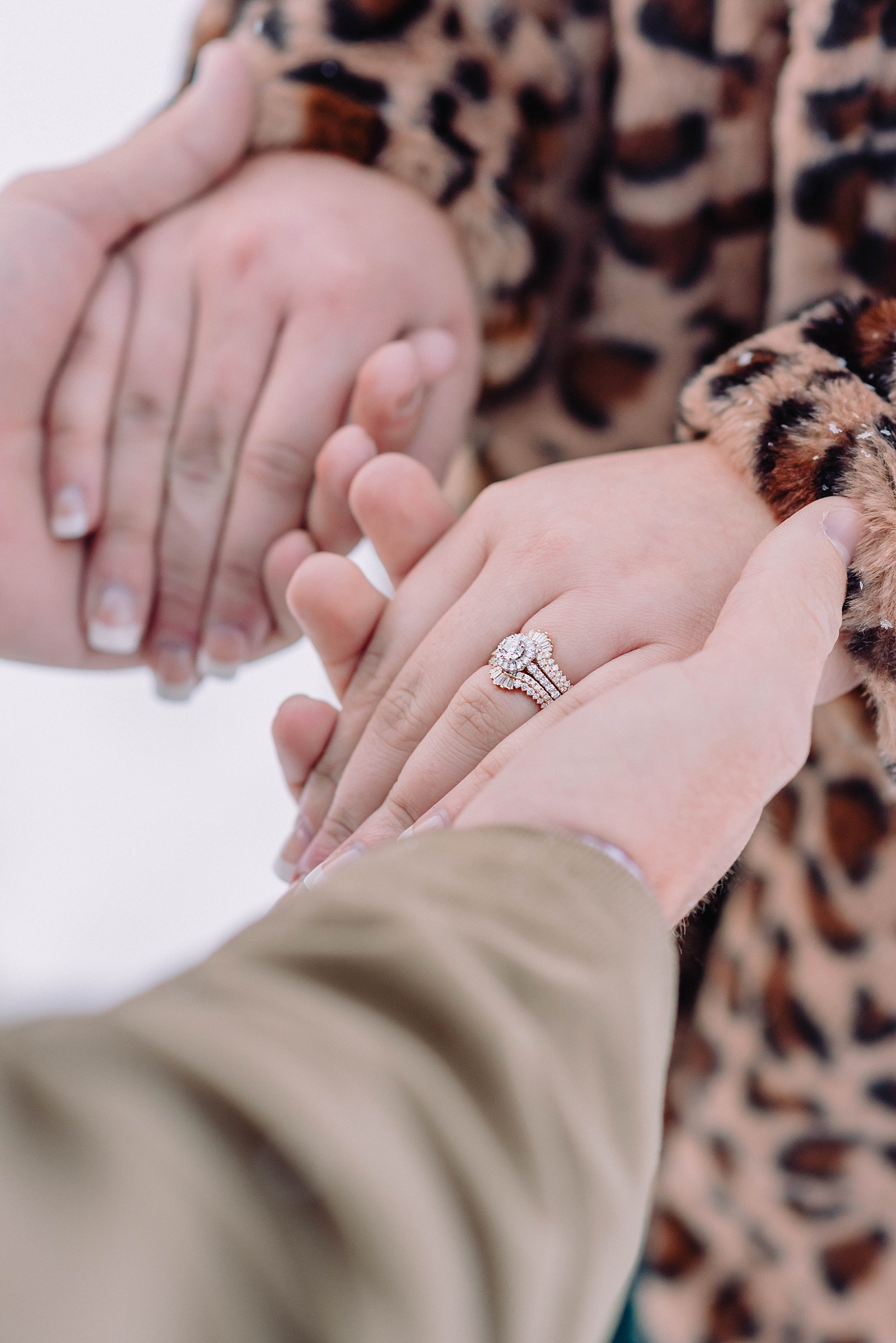 engaged couple holding hands during outdoor winter wedding engagement photos