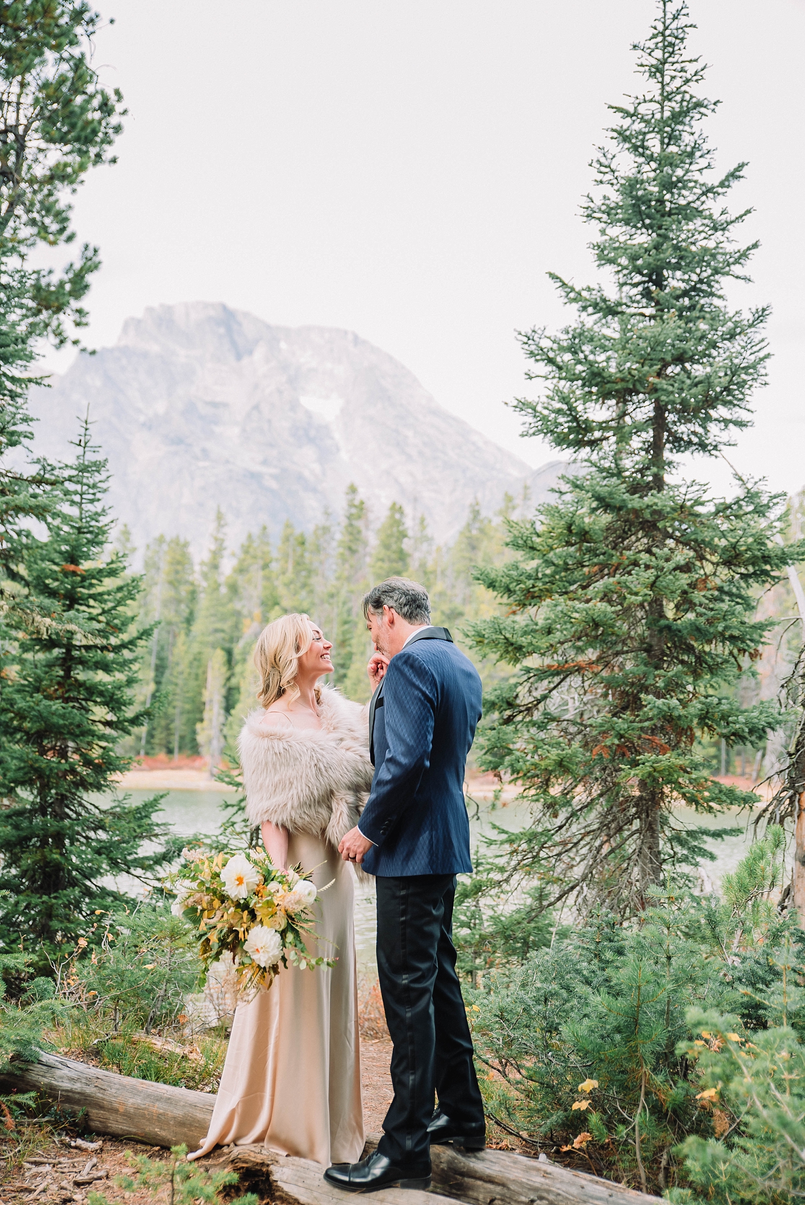 bride and groom standing in the mountains of the Tetons as they elope