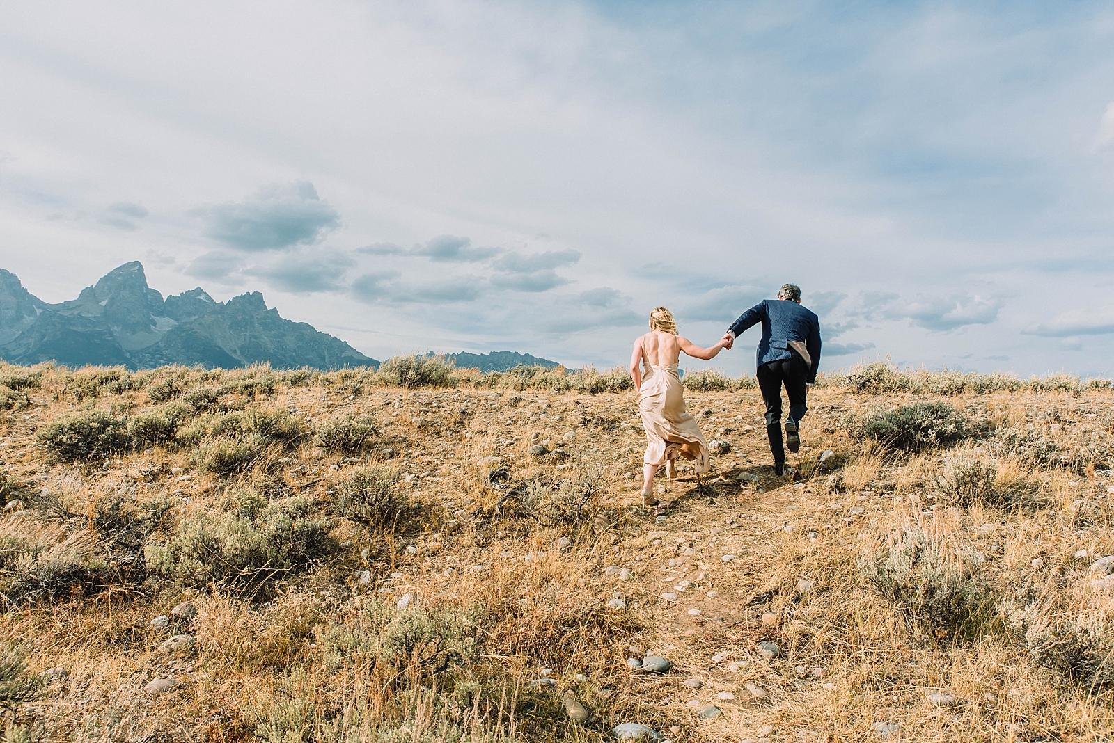 bride and groom running off together after Jackson Hole elopement