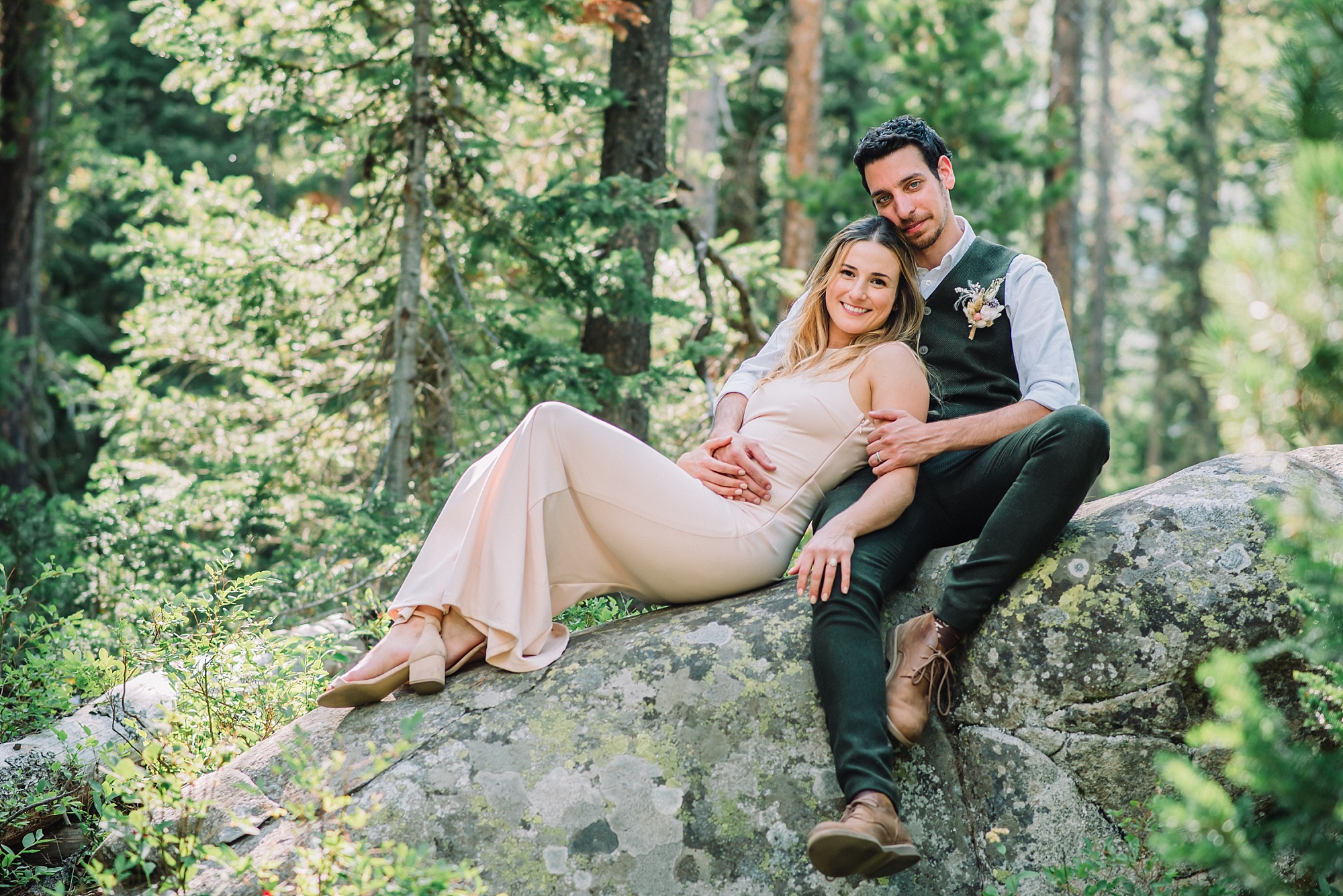 newly married couple sitting on rock at string lake at jackson hole hikng lakes