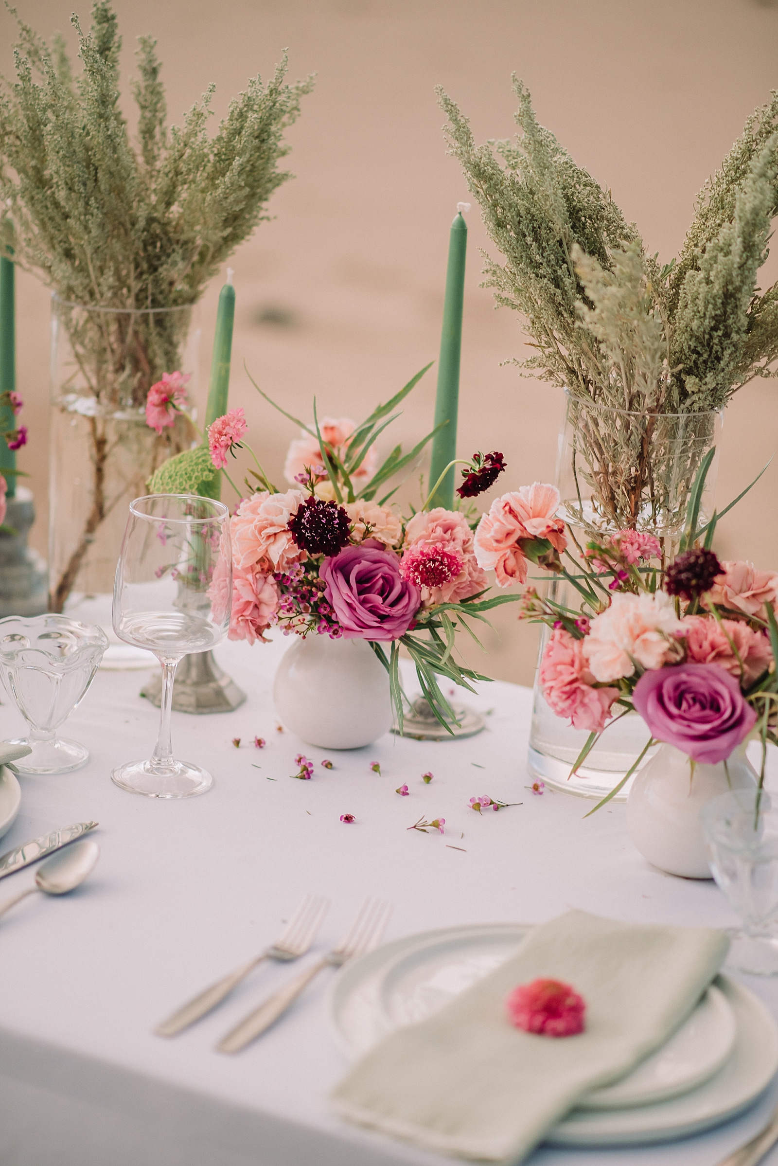 various tones of pink florals on wedding tables with hints of green for beach inspired elopement
