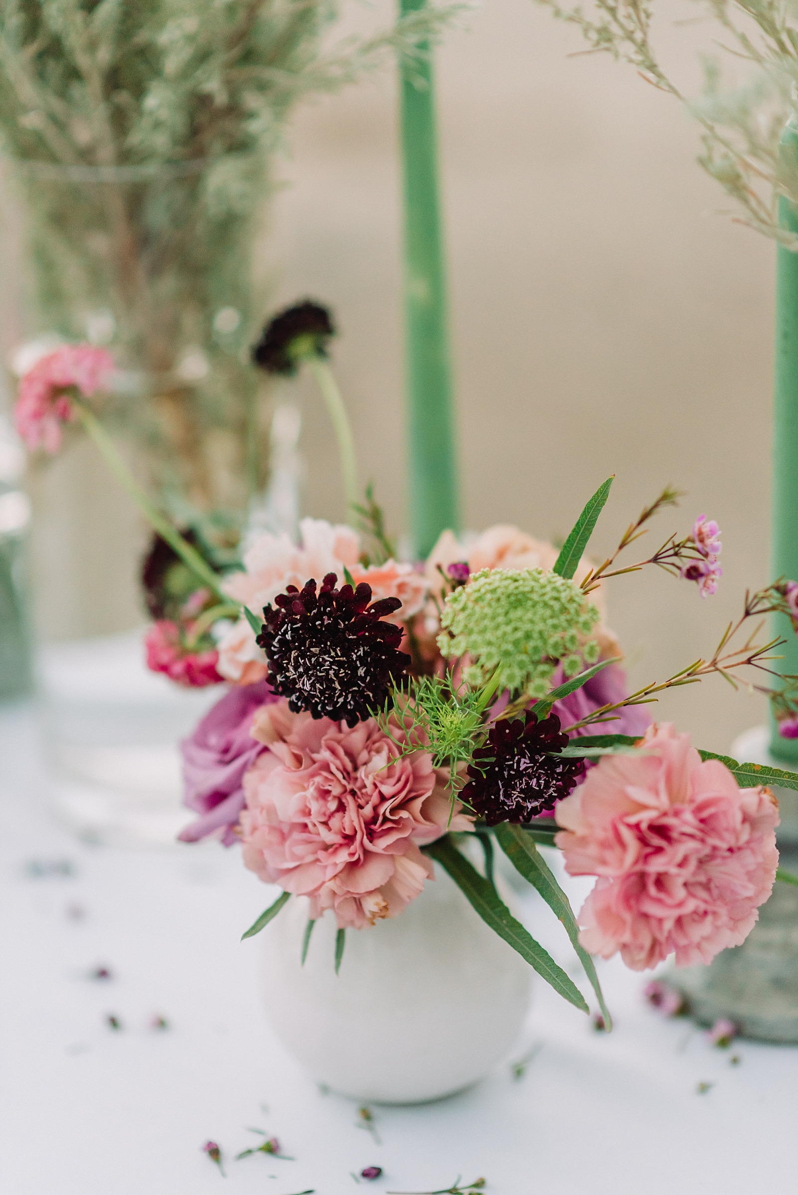 pink and burgundy flowers with hints of green on wedding table