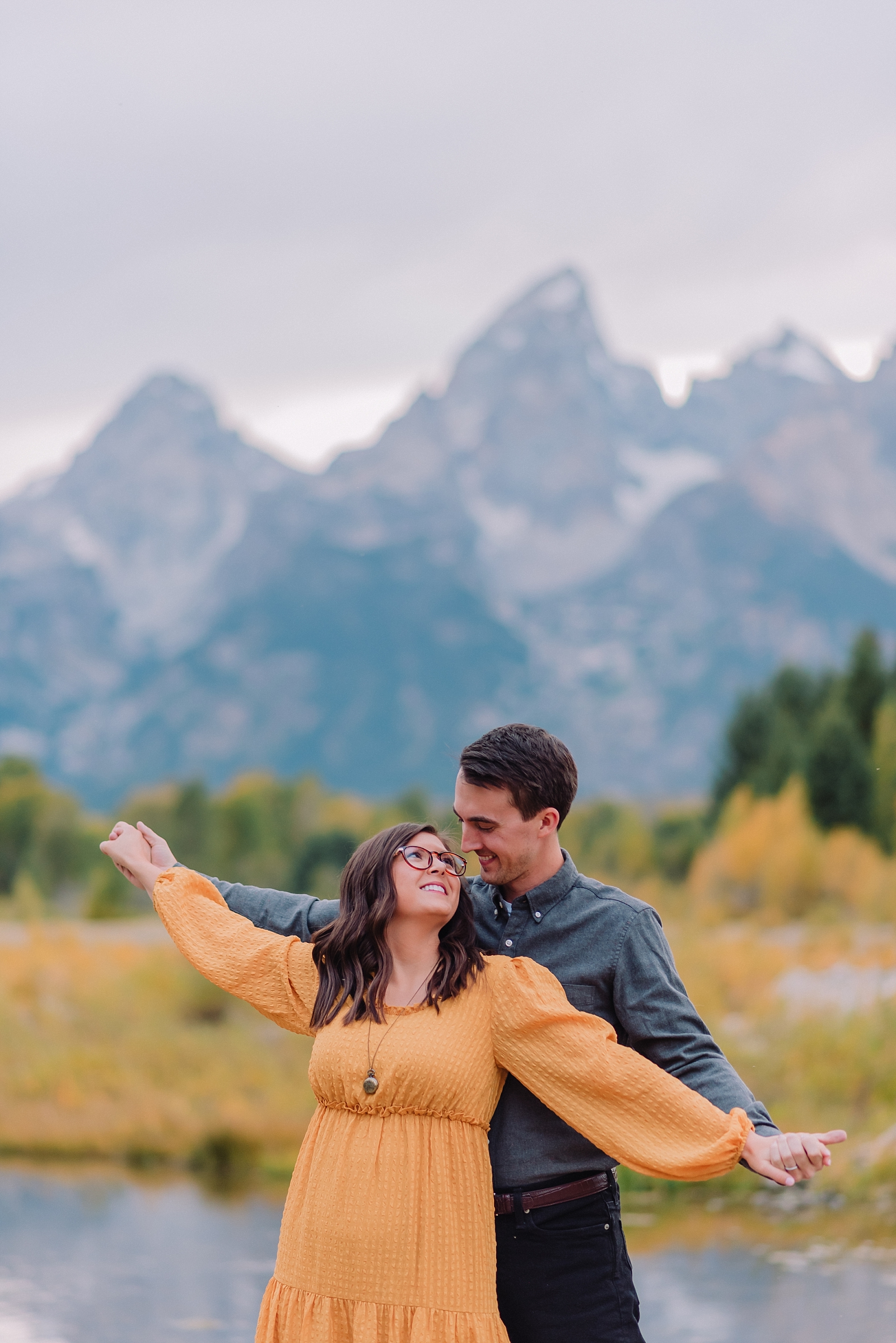 man and woman posing during engagements in tetons