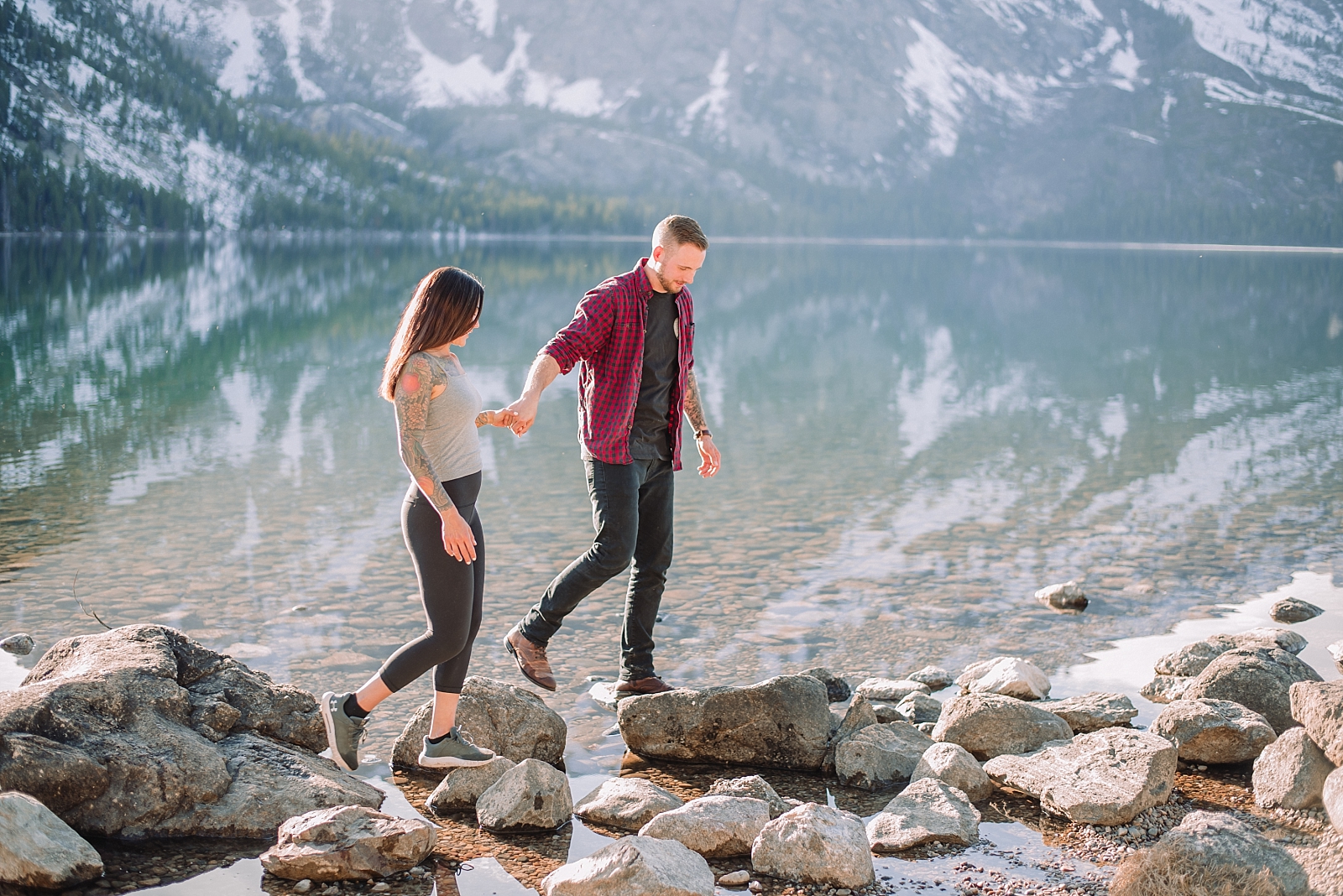 couple walking on the rocks on a lake in Jackson Hole hiking lakes