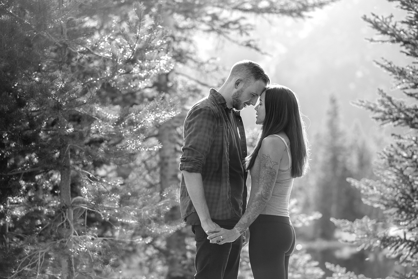 Couple leans heads together in engagement pose