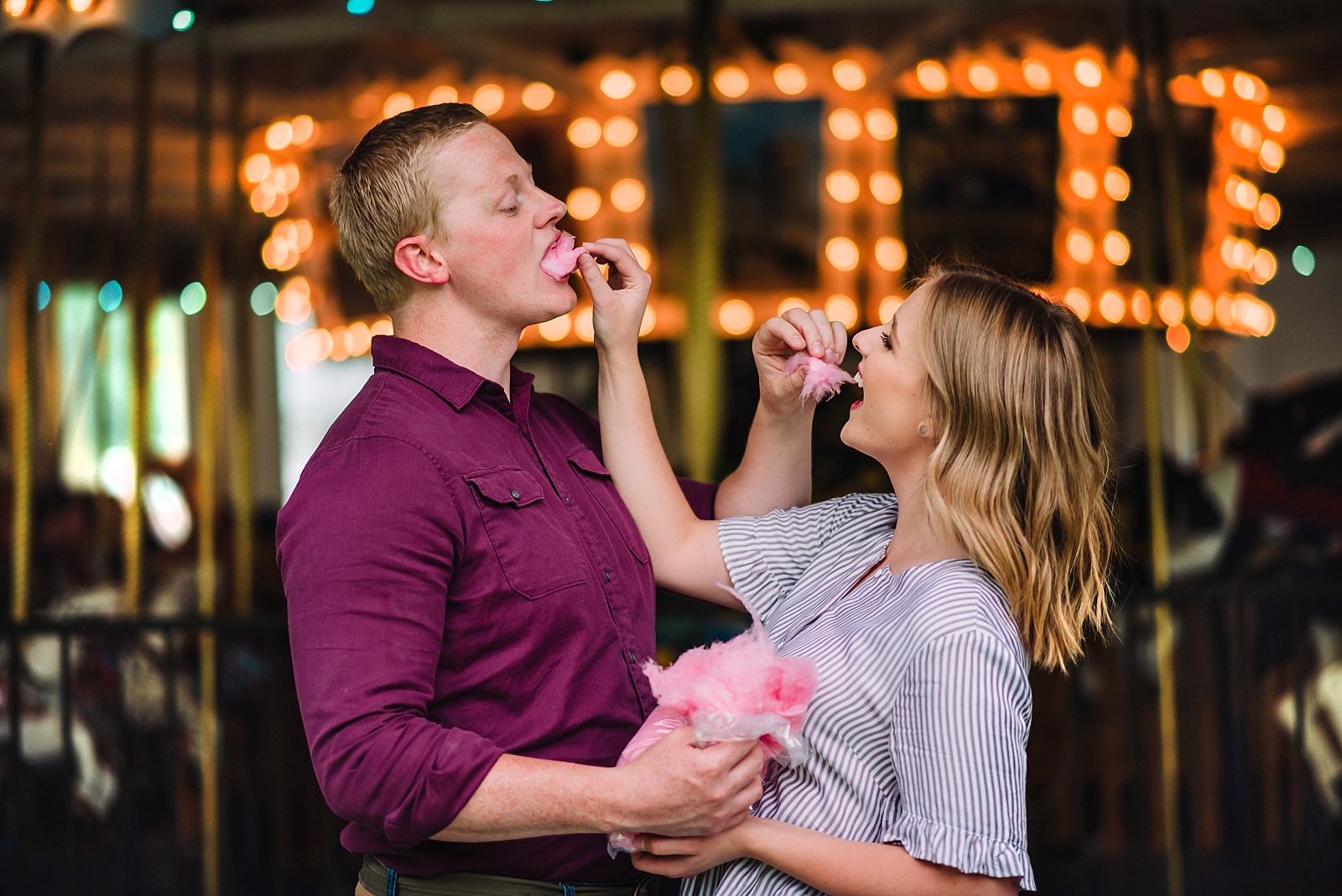 man and woman feeding one another cotton candy