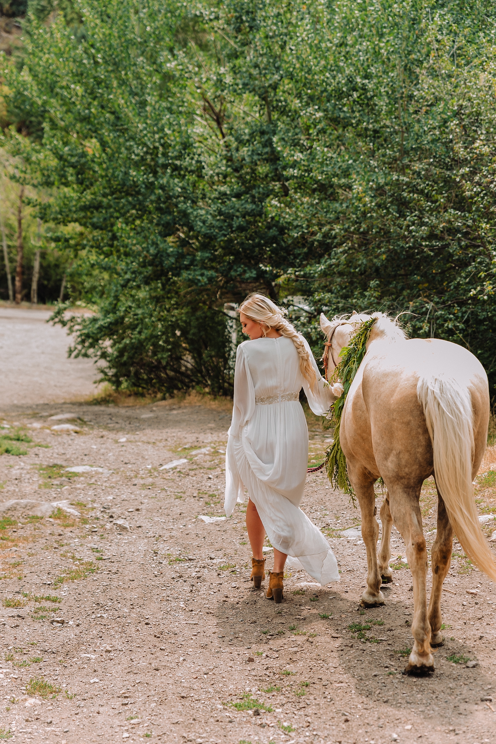 bride walking horse through kelly canyon during styled elopement