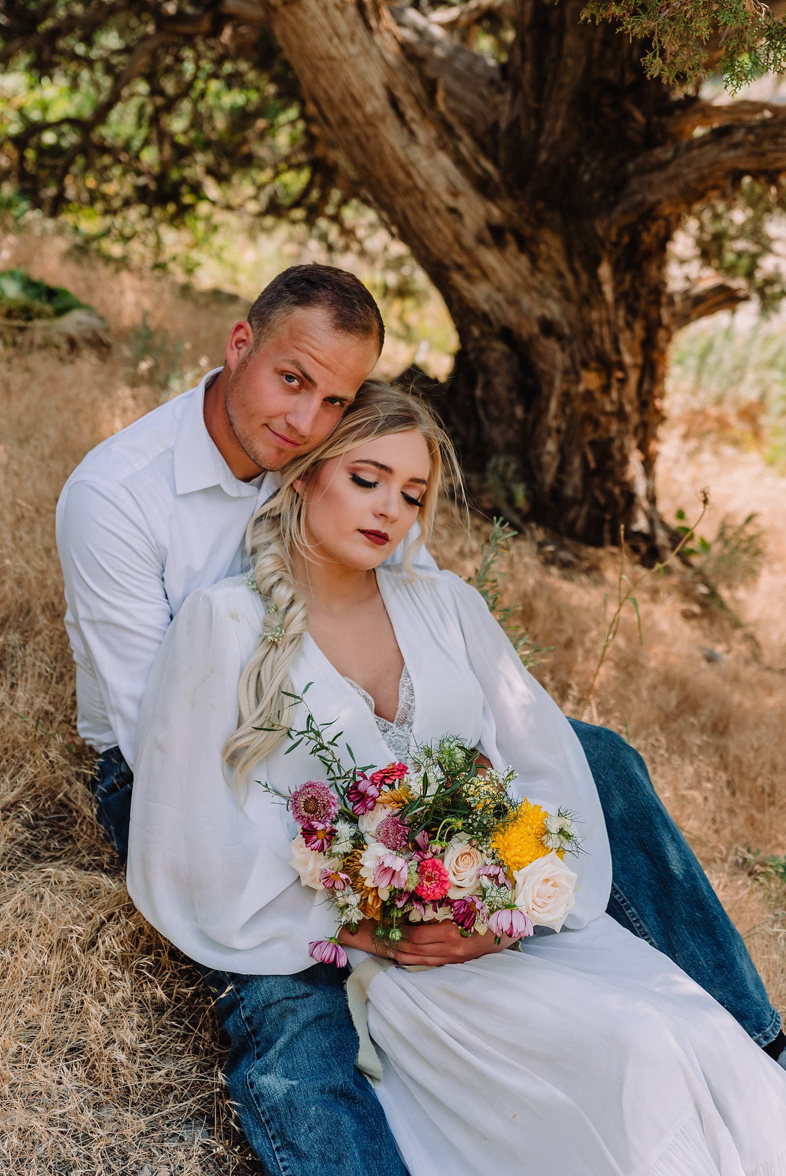bride and groom sitting together in kelly canyon after styled elopement