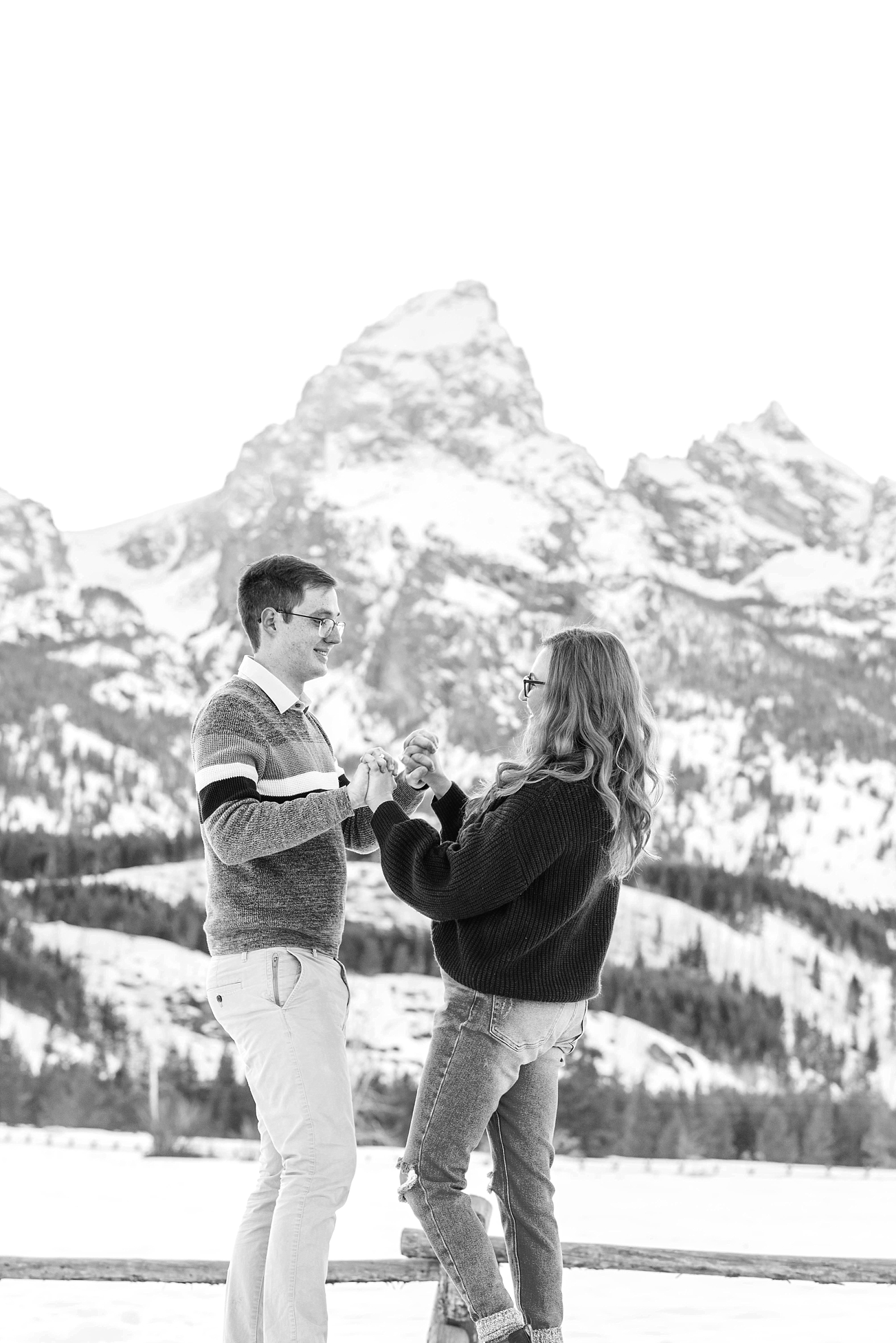 couple holding hands and dancing during spring engagements at taggart lake