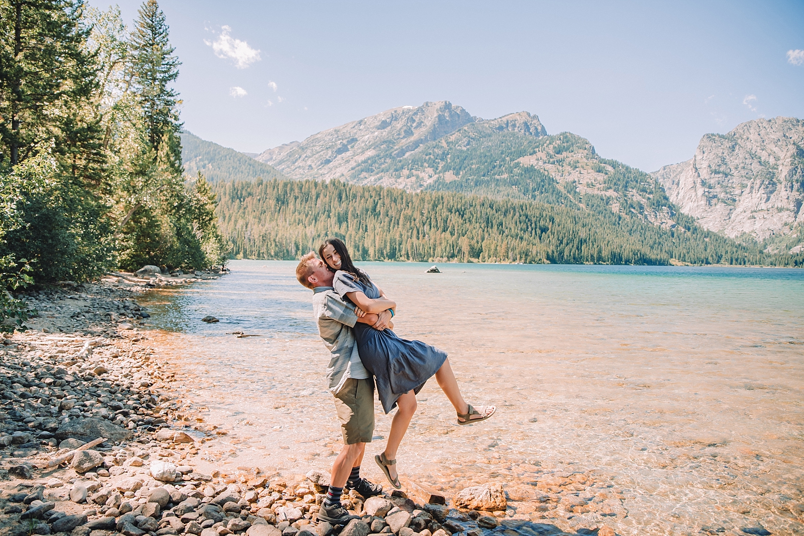 man lifting woman during engagements in the Tetons