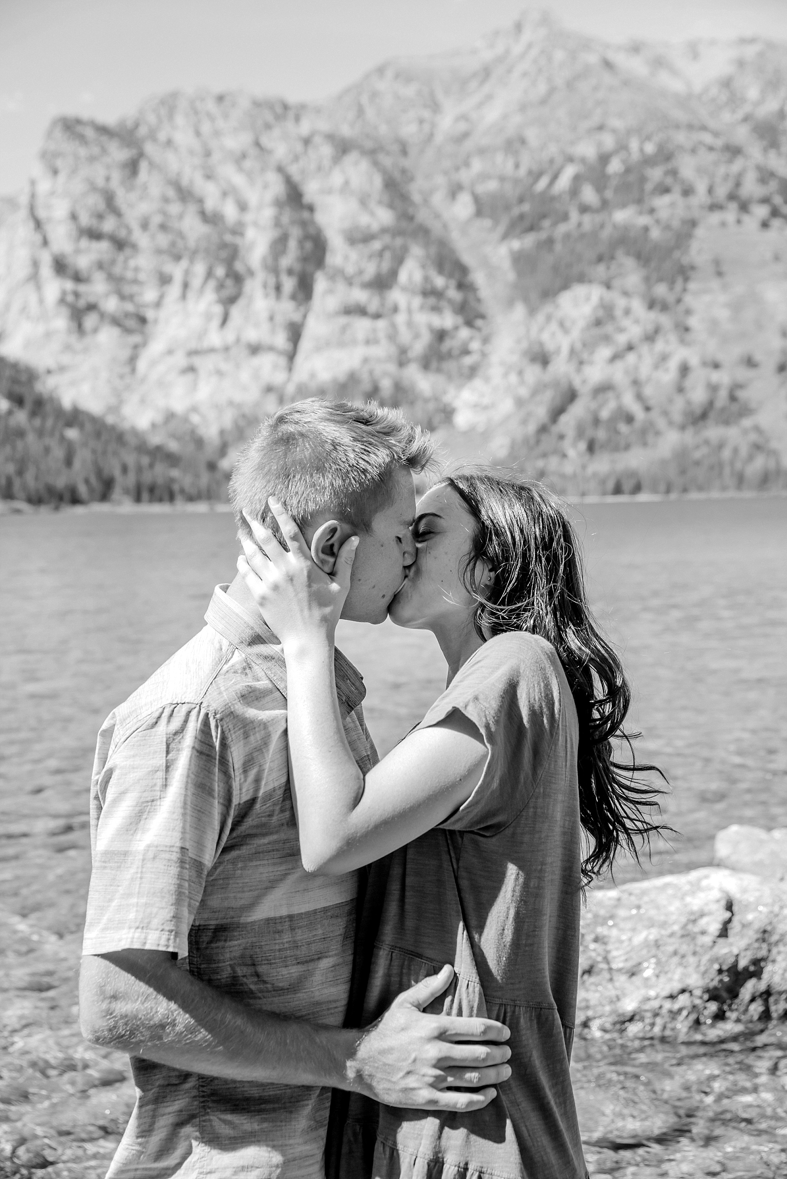 couple kissing on beaches of phelps lake in tetons national park