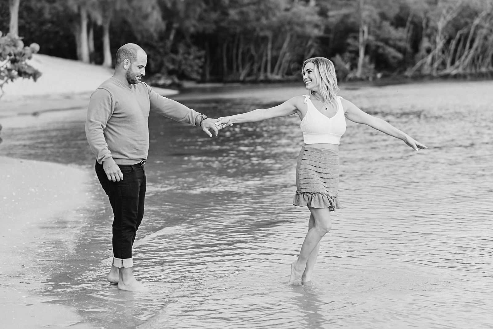 couple walks in water at the beach