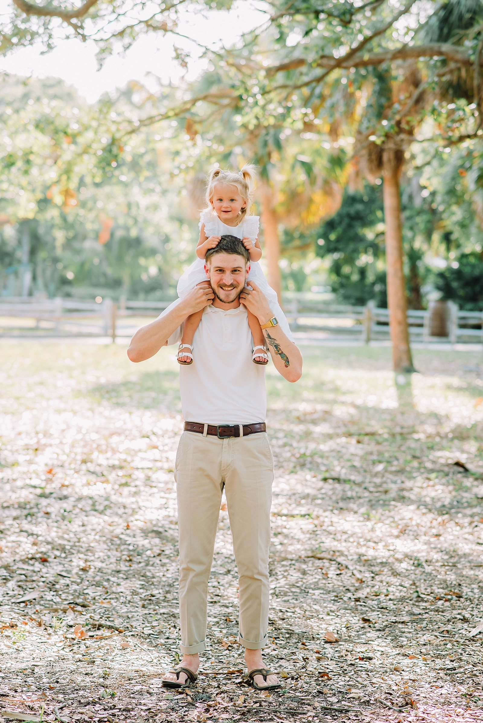 dad holding daughter on shoulders during family photos