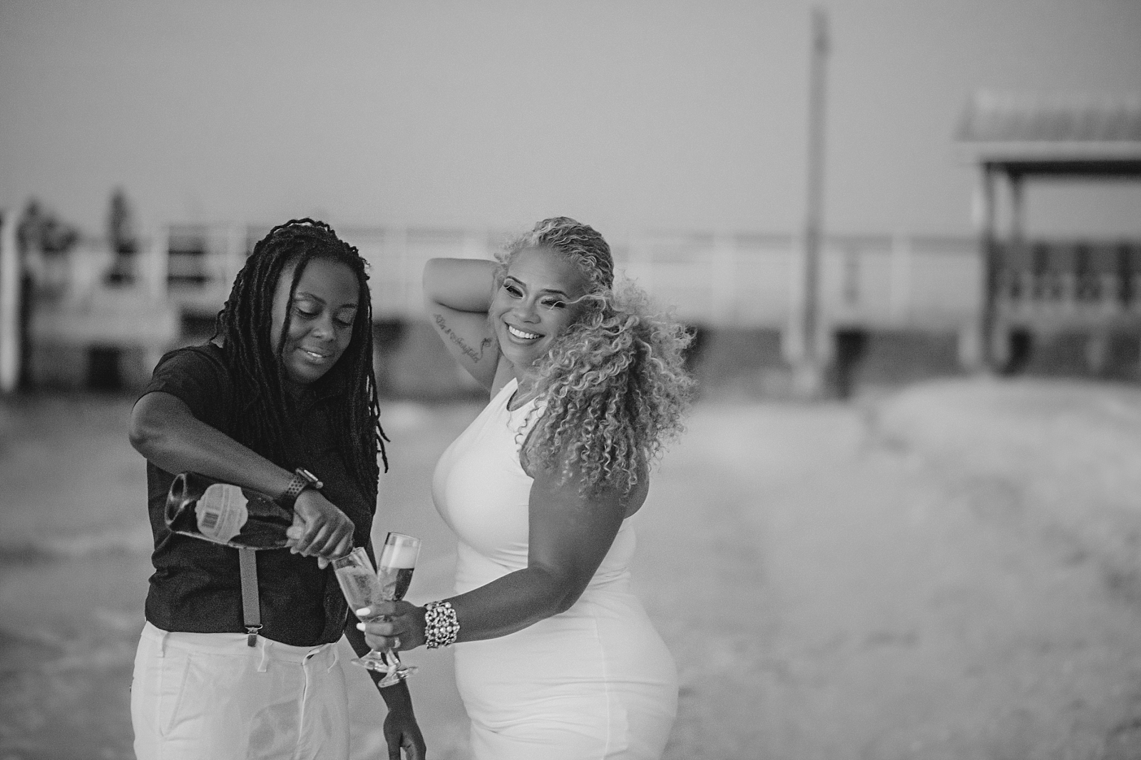 Black Lesbian engagements on Sanibel Island. Same-sex couple celebrates with champagne toasts on the beach in Florida.