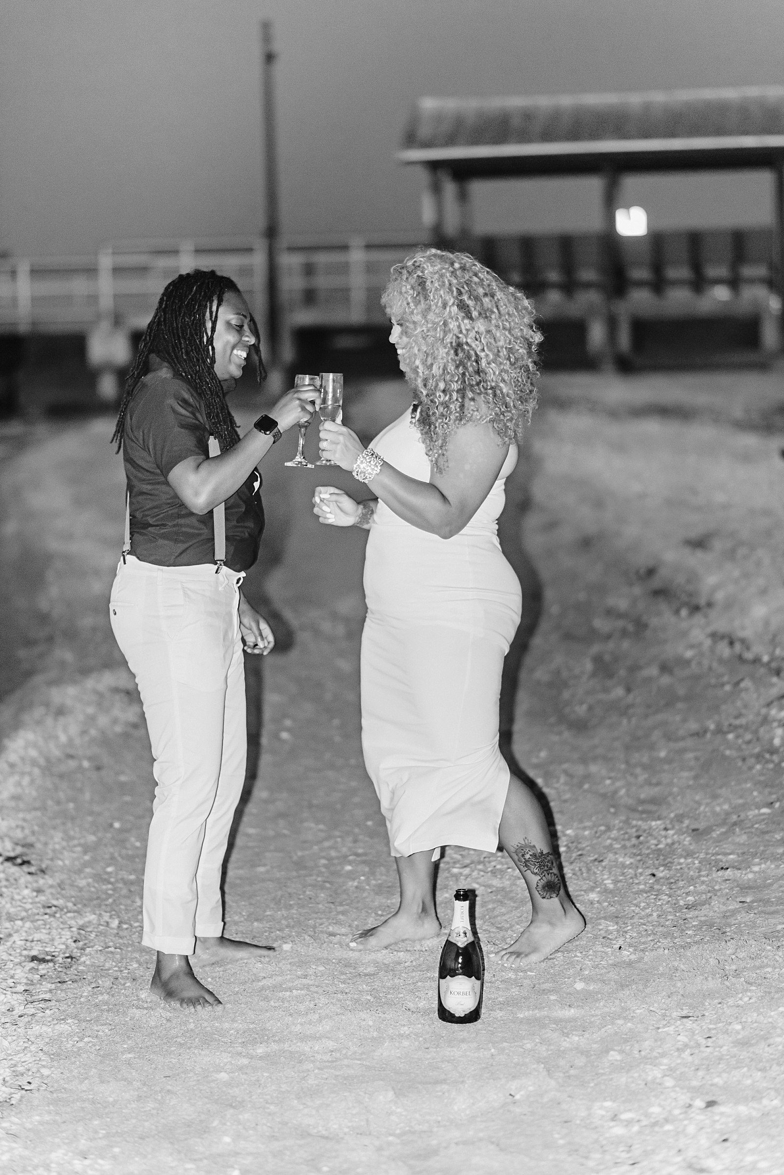 Lesbian engagements on Sanibel Island. Same-sex couple celebrates with champagne toasts on the beach in Florida.