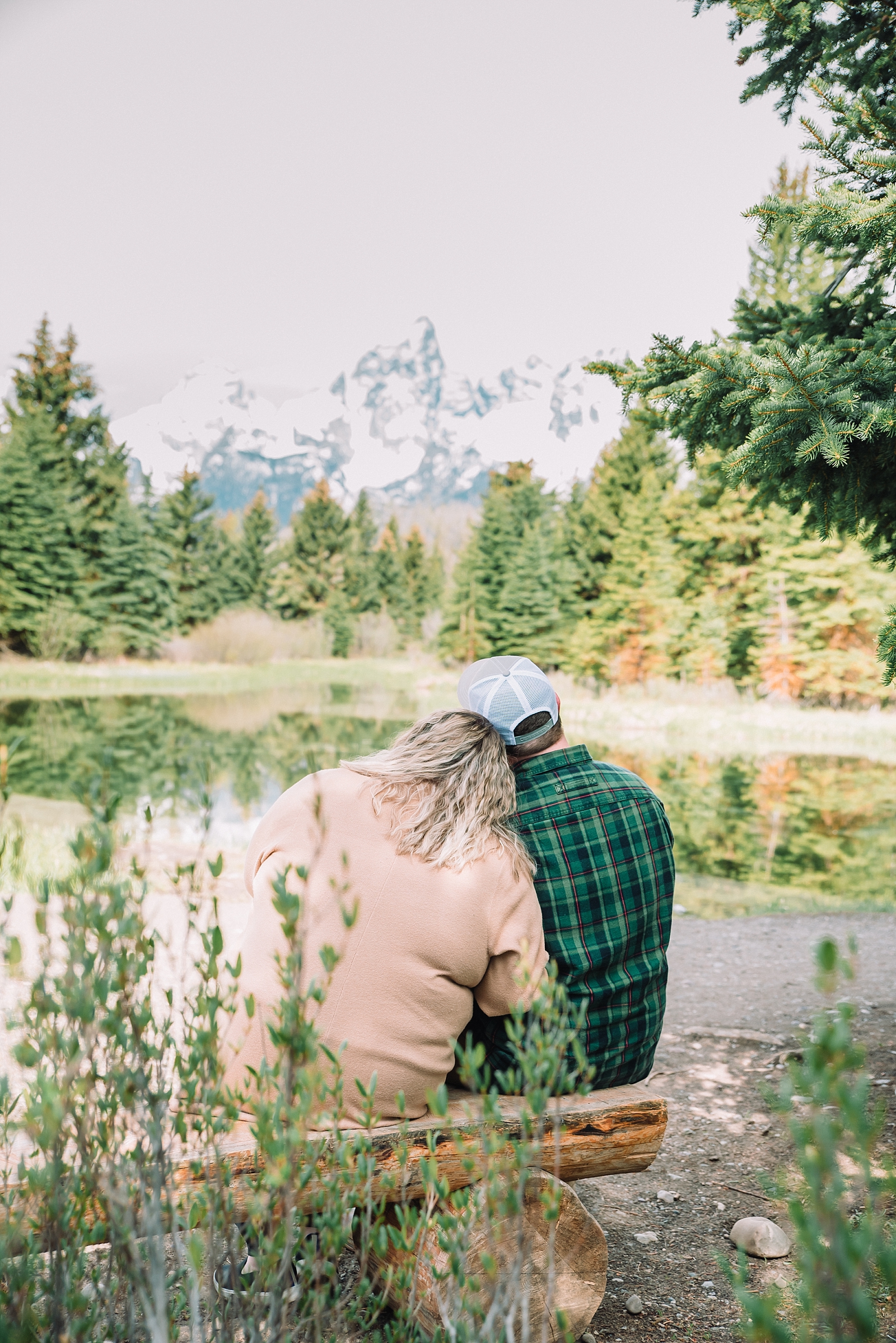 girlfriend lays head on boyfriends shoulder as they look at the Tetons