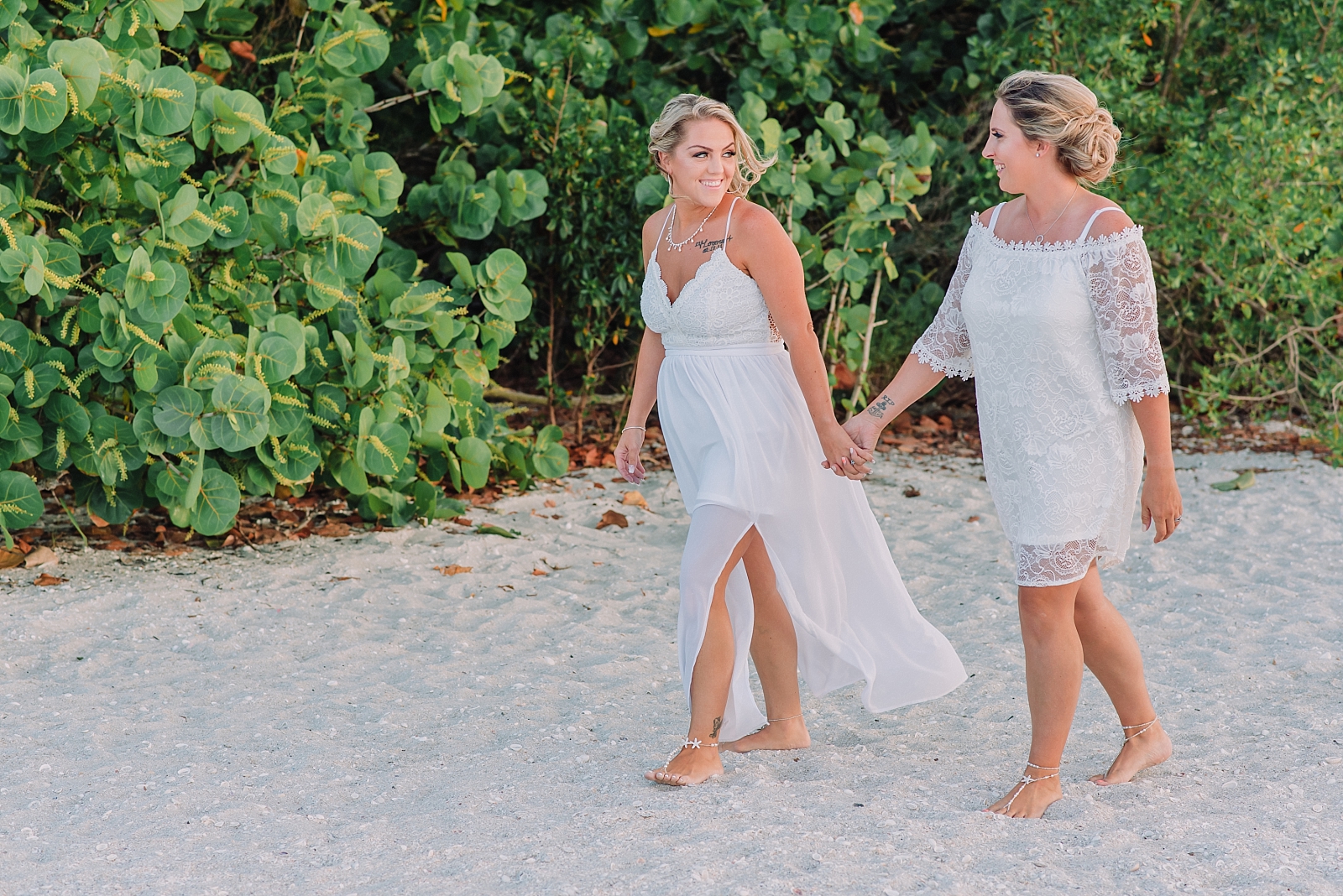 lesbian wedding couple walks on beach