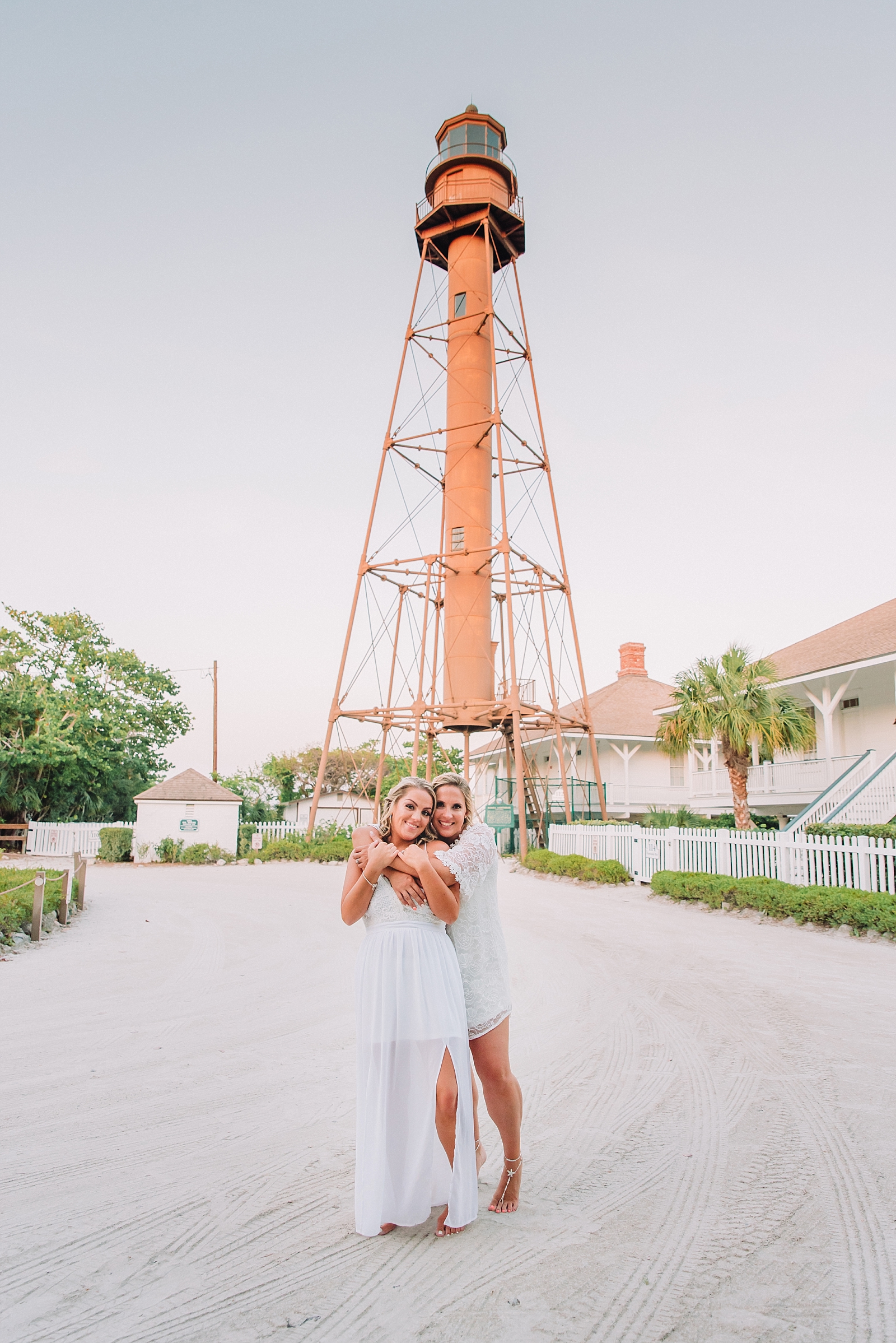 lesbian couple same-sex couple hugs at sanibel island lighthouse wedding