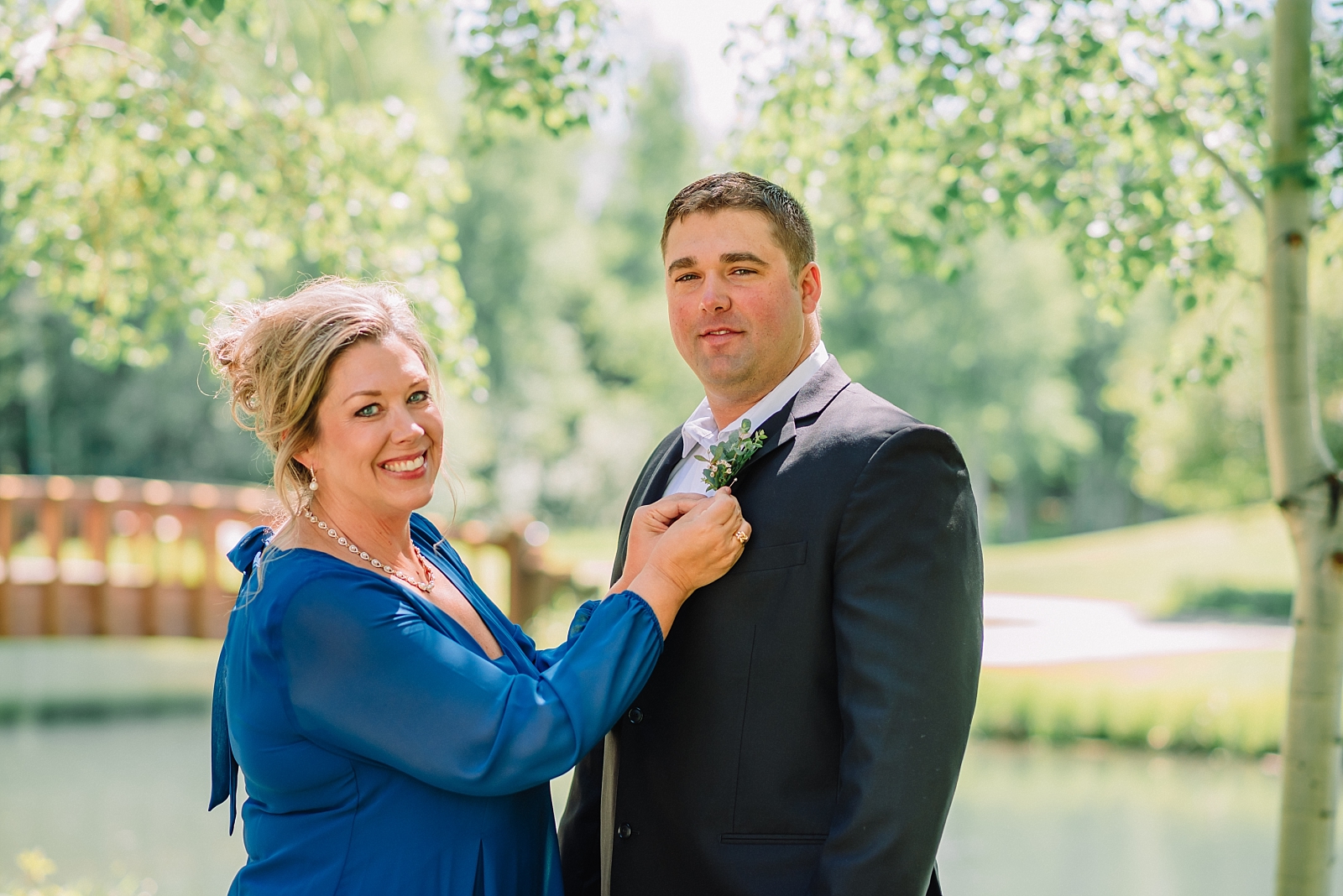 mother of the groom pinning on the groom's boutonniere