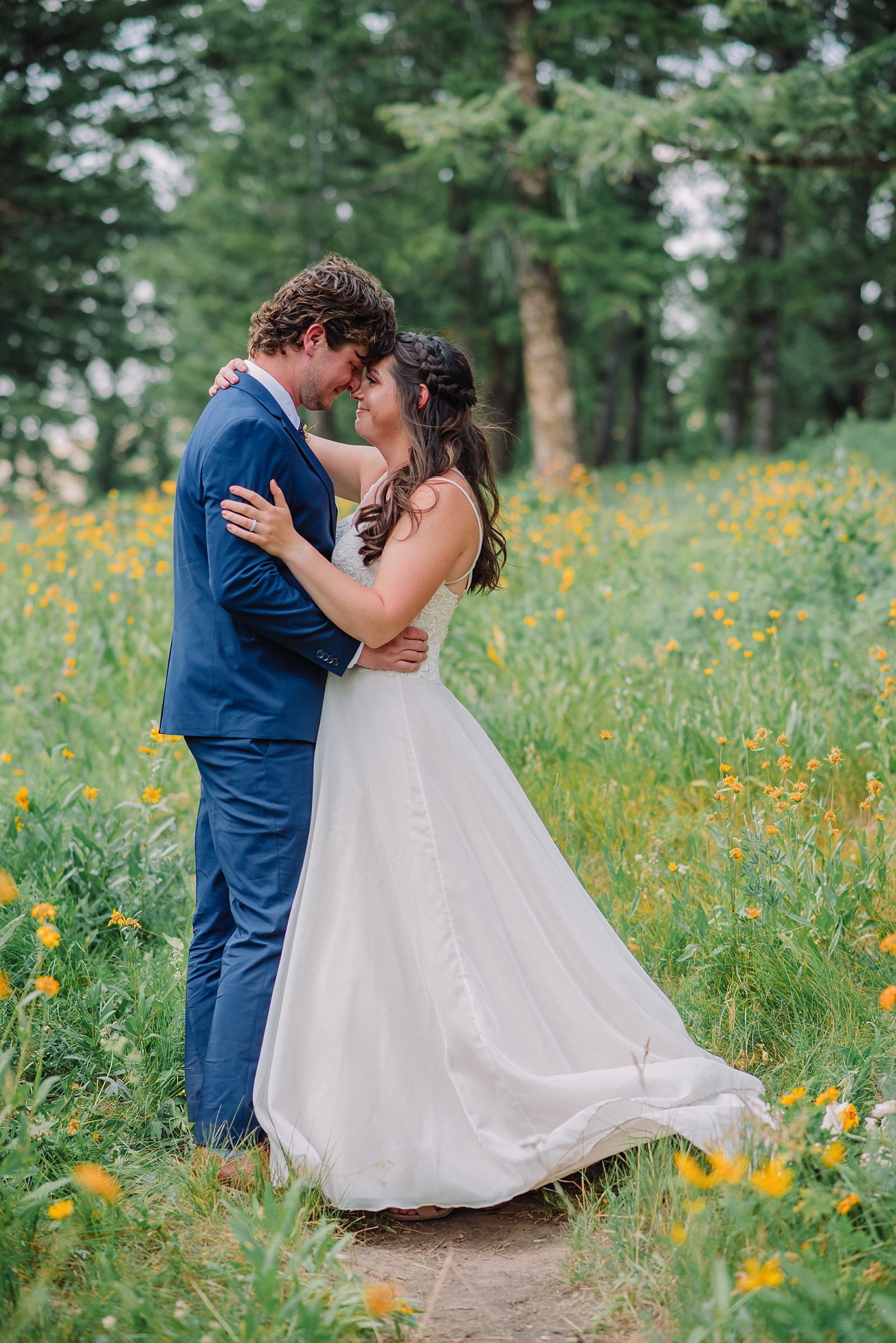bride and groom in field of flowers